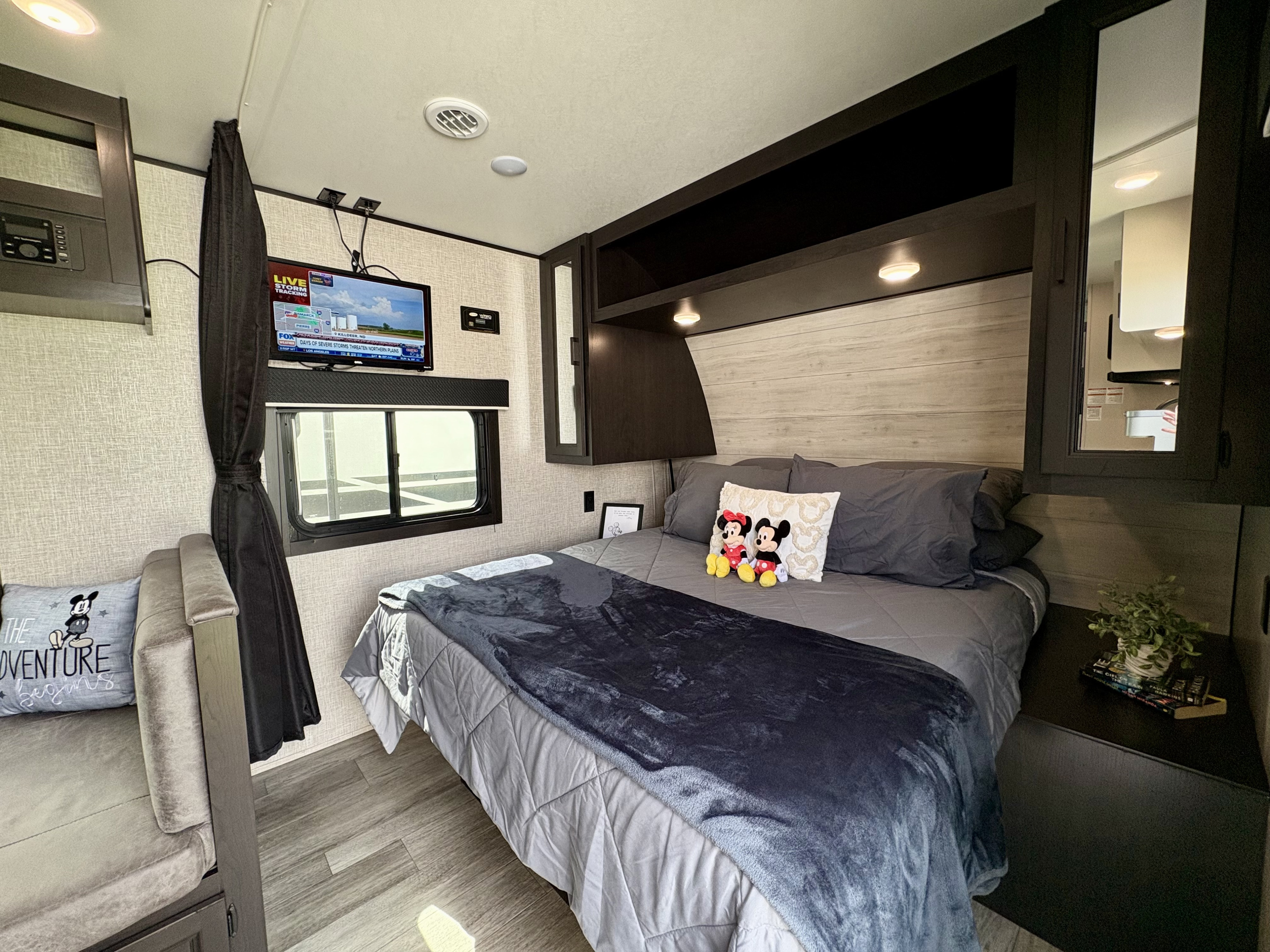 Relax in this cozy RV rental bedroom featuring a comfy bed, TV, and fun Mickey Mouse accents.. Jayco Jay Flight 2023