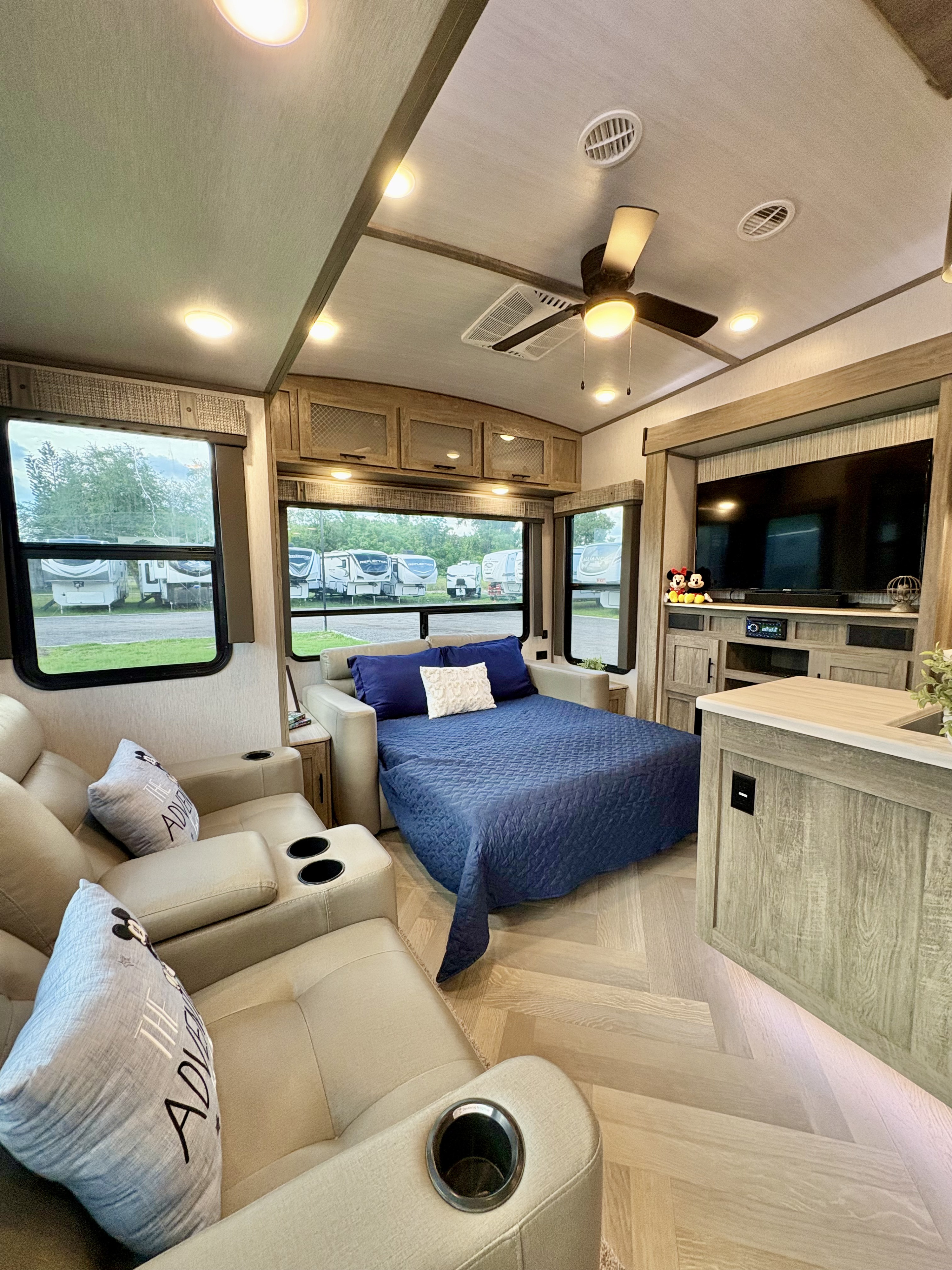 Modern RV rental living space with comfy recliners, a sofa bed, and TV. Bright, light wood interior, great for travel.. Forest River Salem Hemisphere 2022
