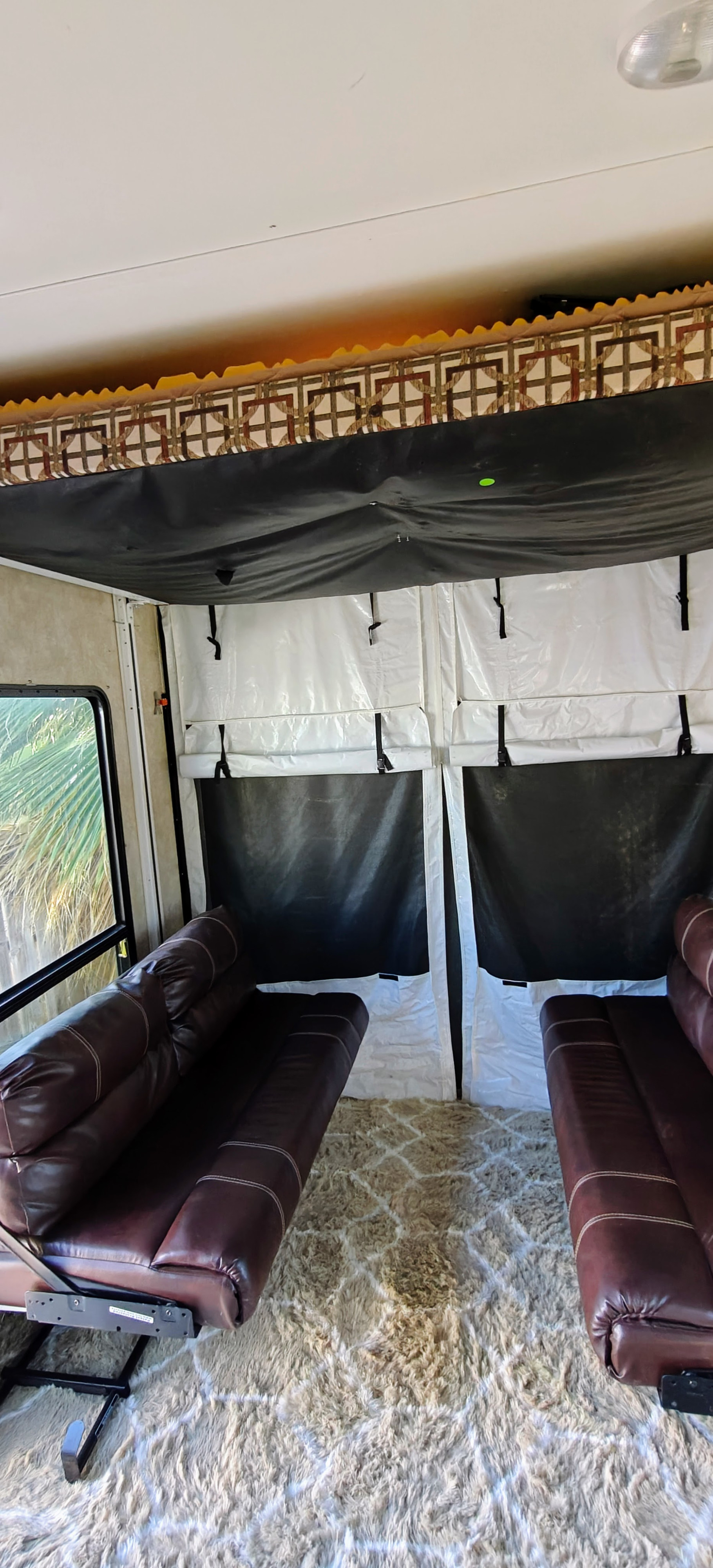 Spacious RV rental interior with brown leather sofas, plush rug, and screen room setup, perfect for relaxation.. Keystone Carbon 2015