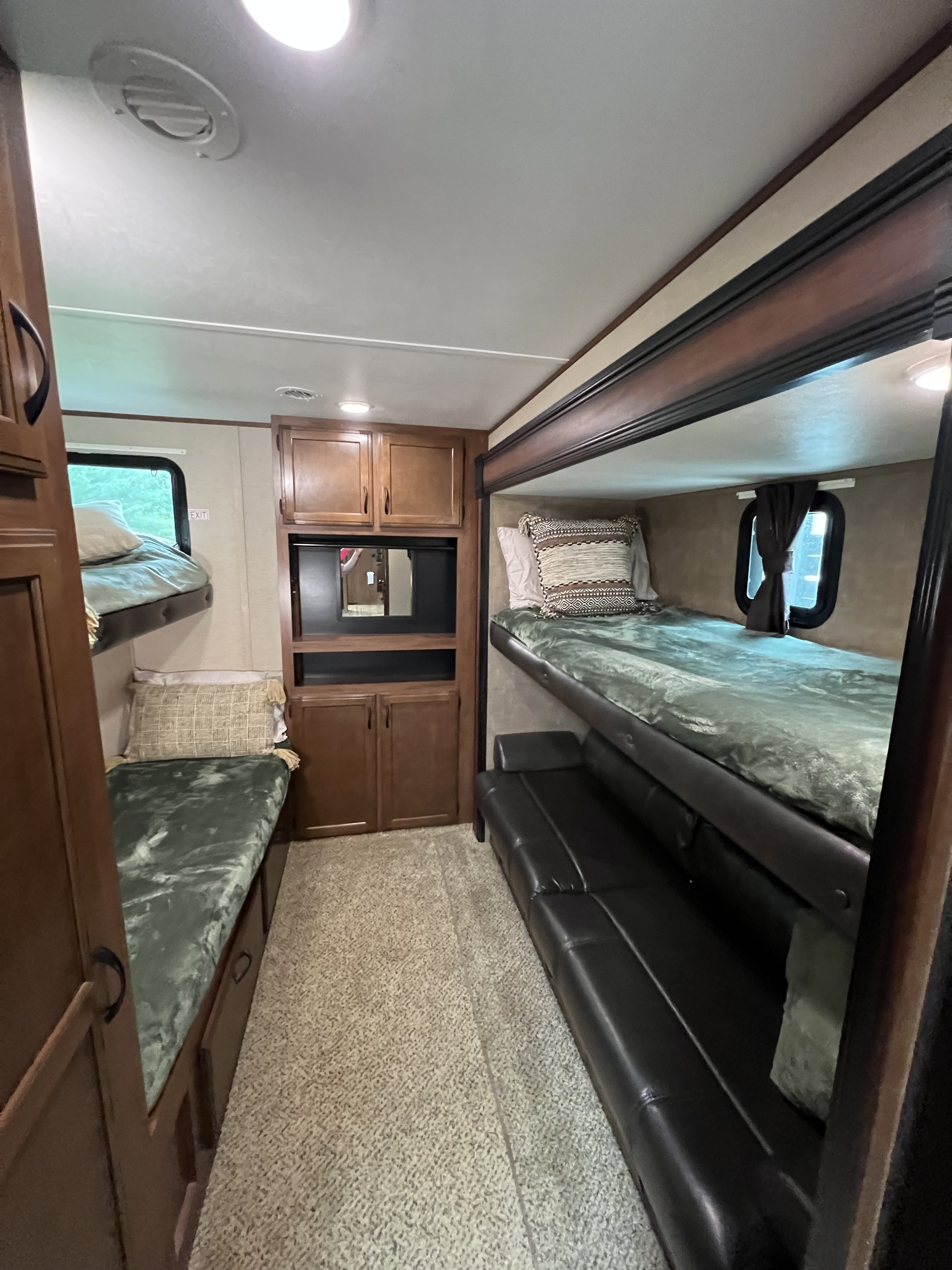 Inside an RV rental bunkhouse featuring comfortable bunk beds, a lower sofa, and storage cabinetry. Perfect for family adventures.. Jayco Jay Flight 2016