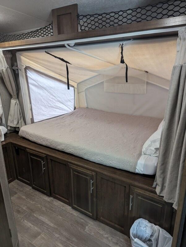 RV rental: Cozy camper interior featuring a pop-out bed, built-in storage cabinets, and overhead netting for extra space.. Forest River Flagstaff Shamrock 2020