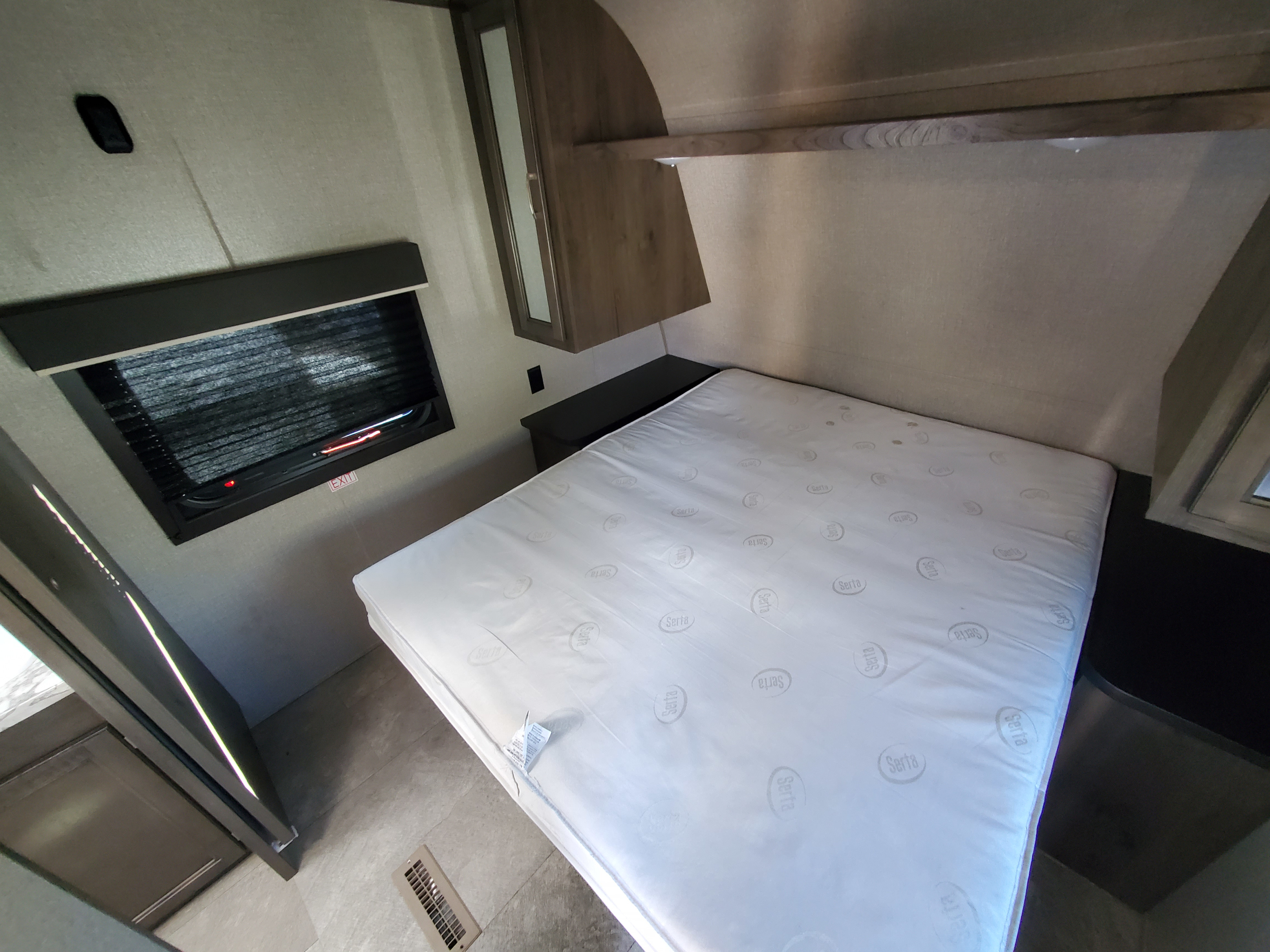 Inside an RV rental bedroom: a Serta mattress, overhead cabinets, and an emergency exit window with blinds.. Jayco Jay Flight SLX 2021