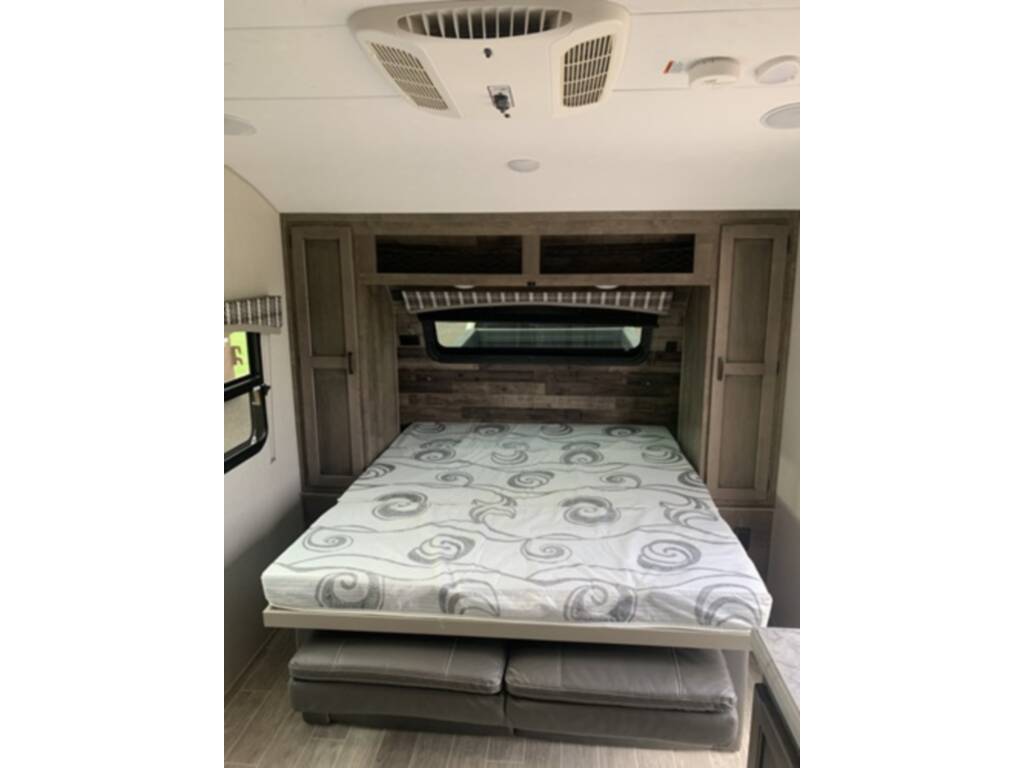 RV rental: This cozy bedroom features a patterned queen bed with under-bed seating, built-in storage, and AC.. Sonic Lite 2021