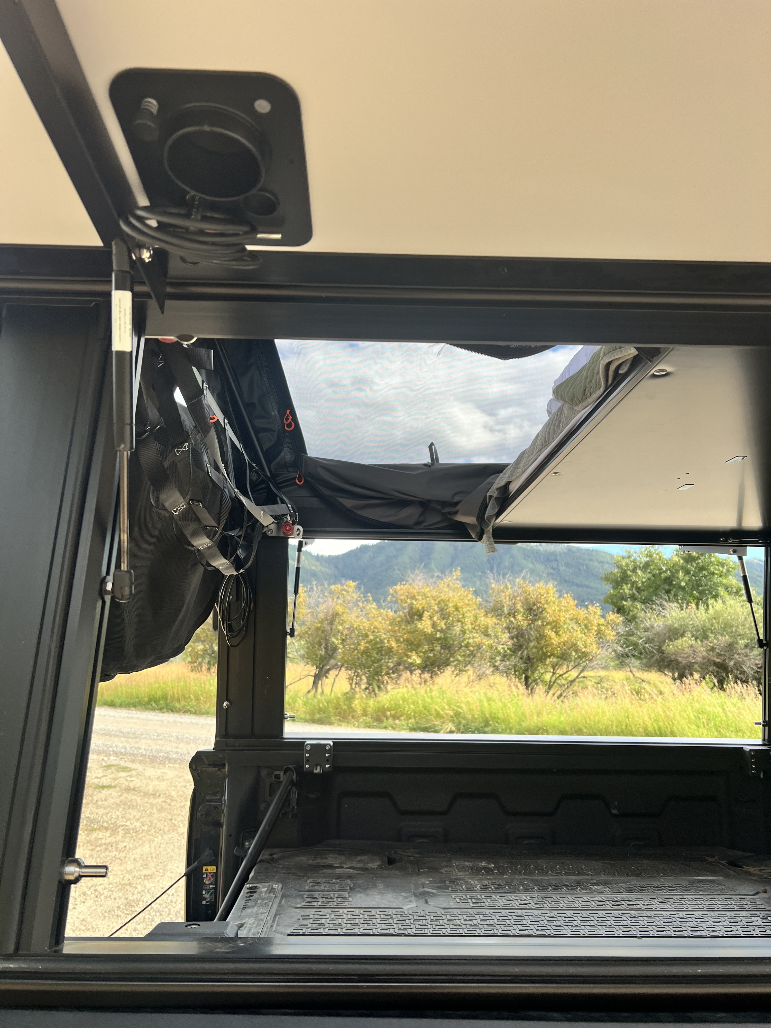 Relax inside this RV rental truck bed camper. An open pop-top and mesh window offer serene views of mountains and nature.. Gmc Custom 2023