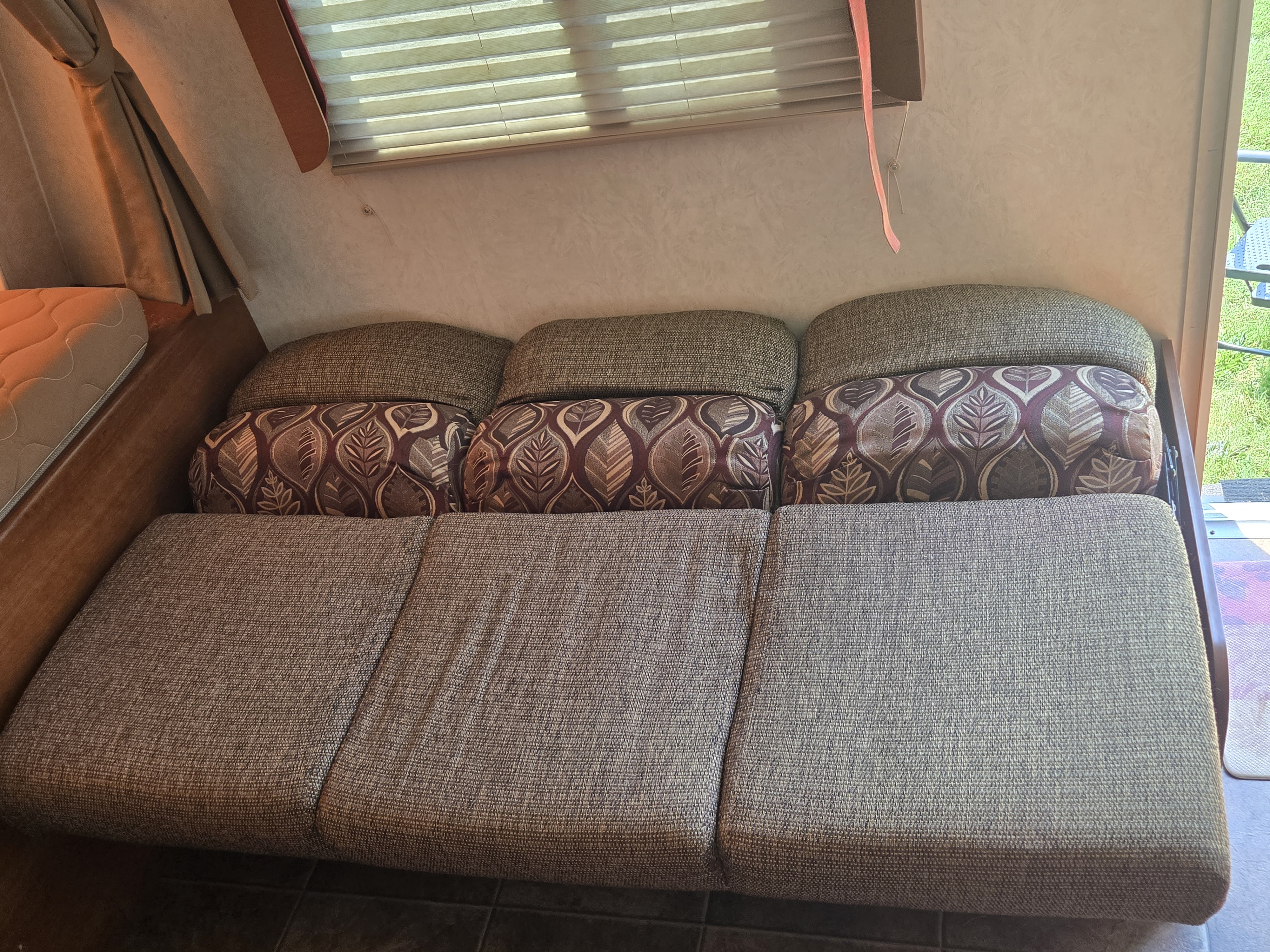 Cozy RV rental interior with sofa/dinette setup and decorative cushions, perfect for relaxing on your trip.. Coachmen Freedom express ltz 2014