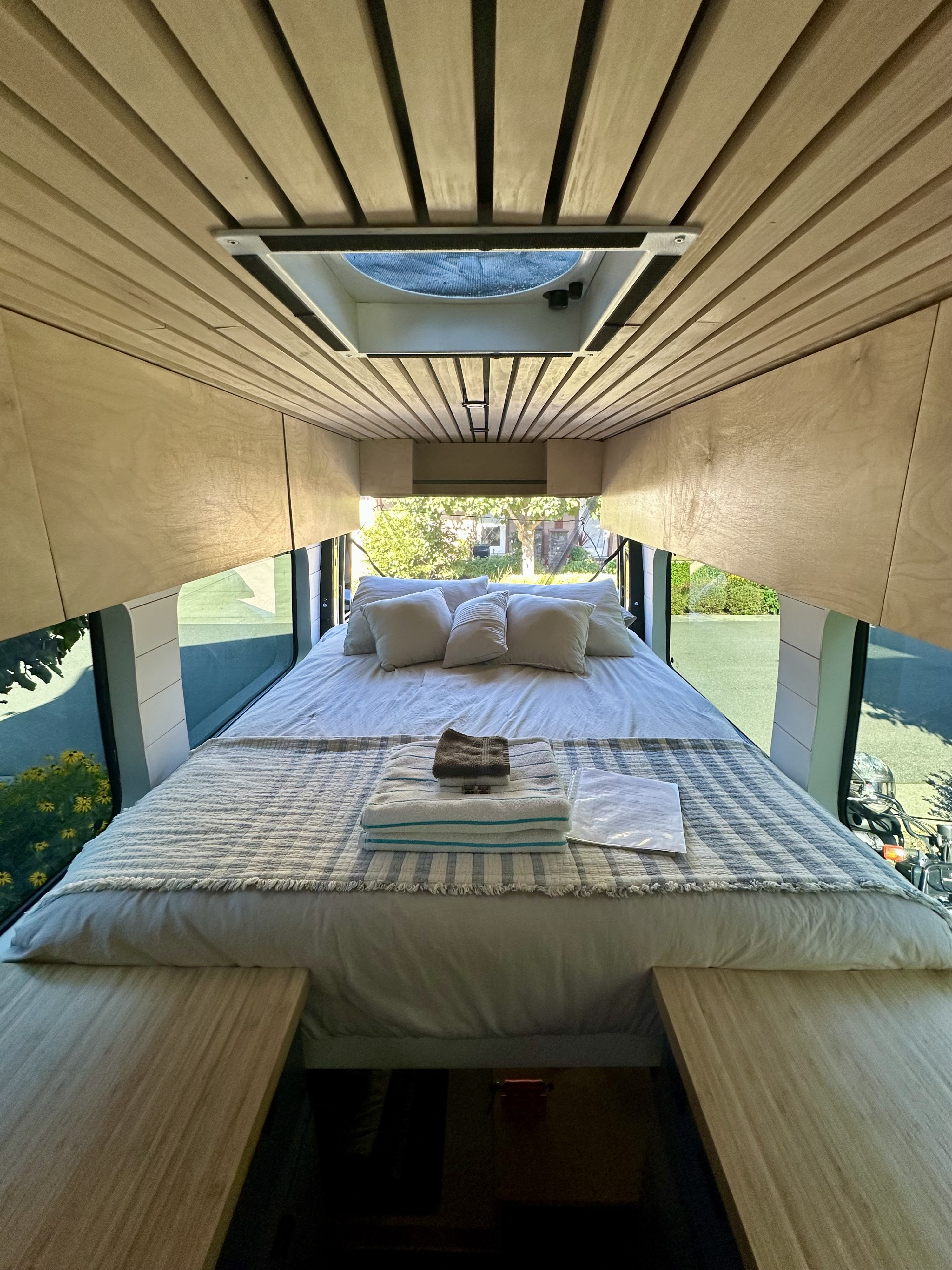 Cozy RV rental interior: a comfy bed, wood ceiling, and scenic window views. Perfect for your next adventure.. Mercedes Sprinter 2007