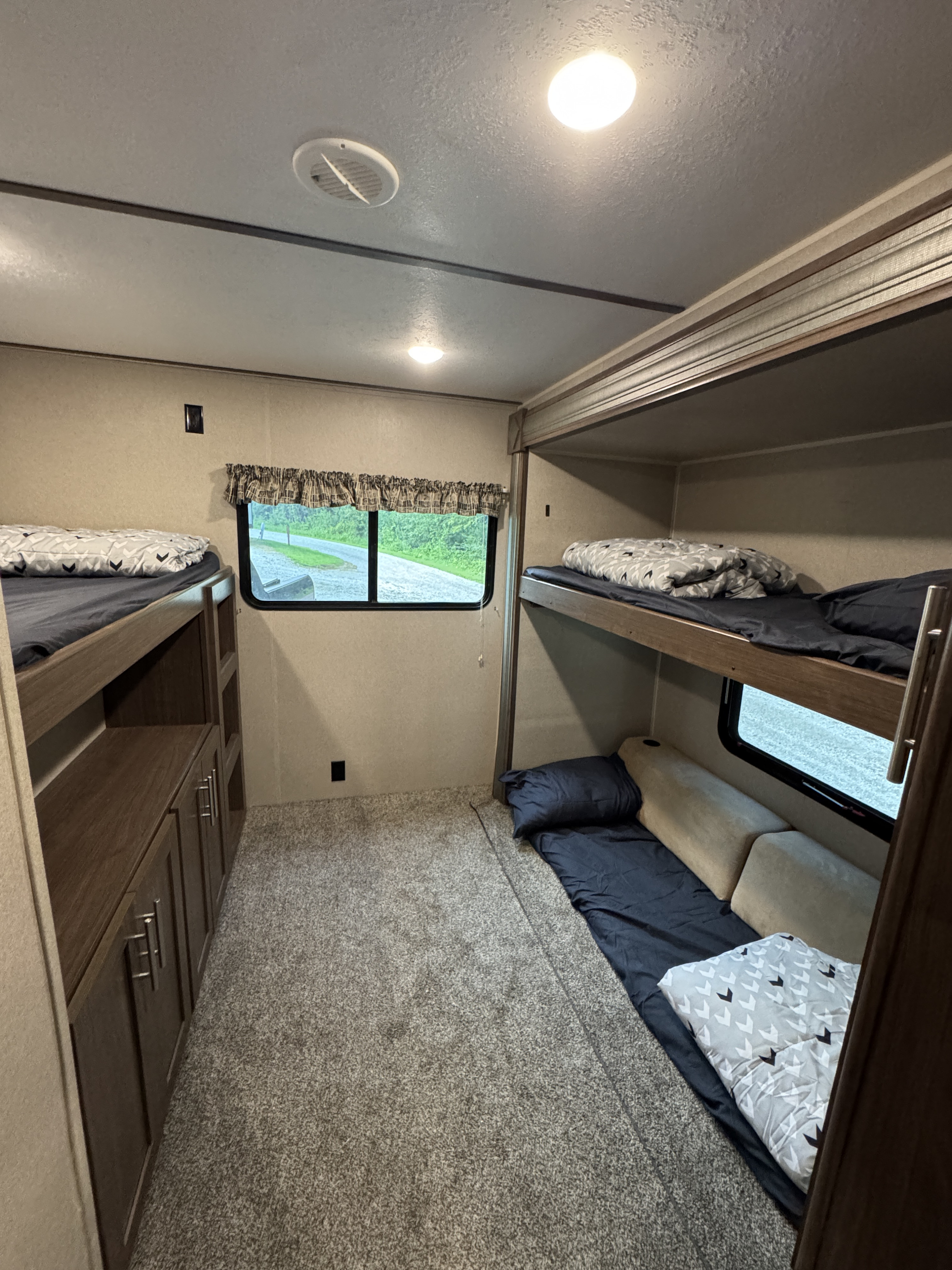 Spacious RV rental bunkhouse featuring two sets of comfortable bunk beds, ideal for family travel. Includes storage and a scenic window.. Keystone RV Hideout 2019