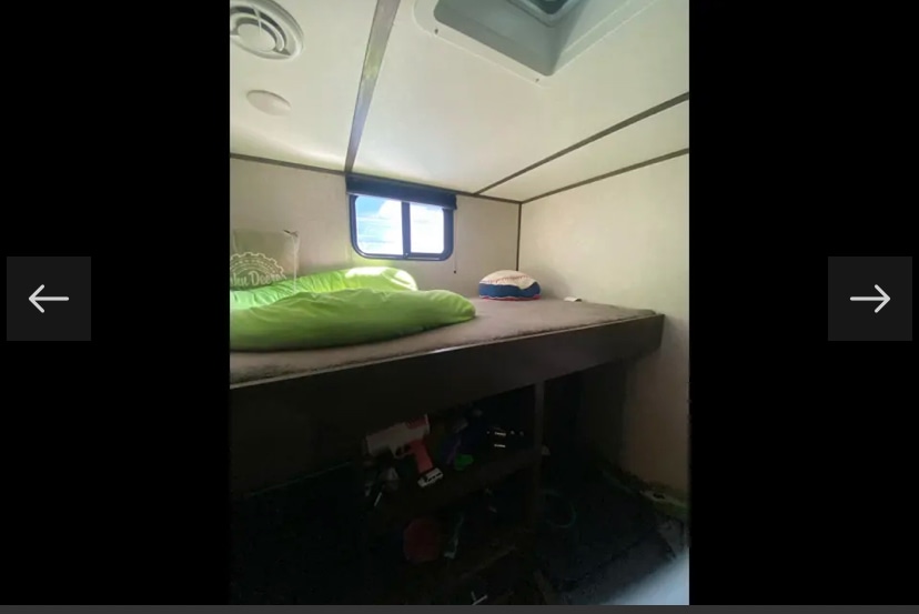 Inside this RV rental: a cozy bunk bed setup with a green sleeping bag, window, and under-bed storage, ideal for families.. Coachmen Lantern 2021