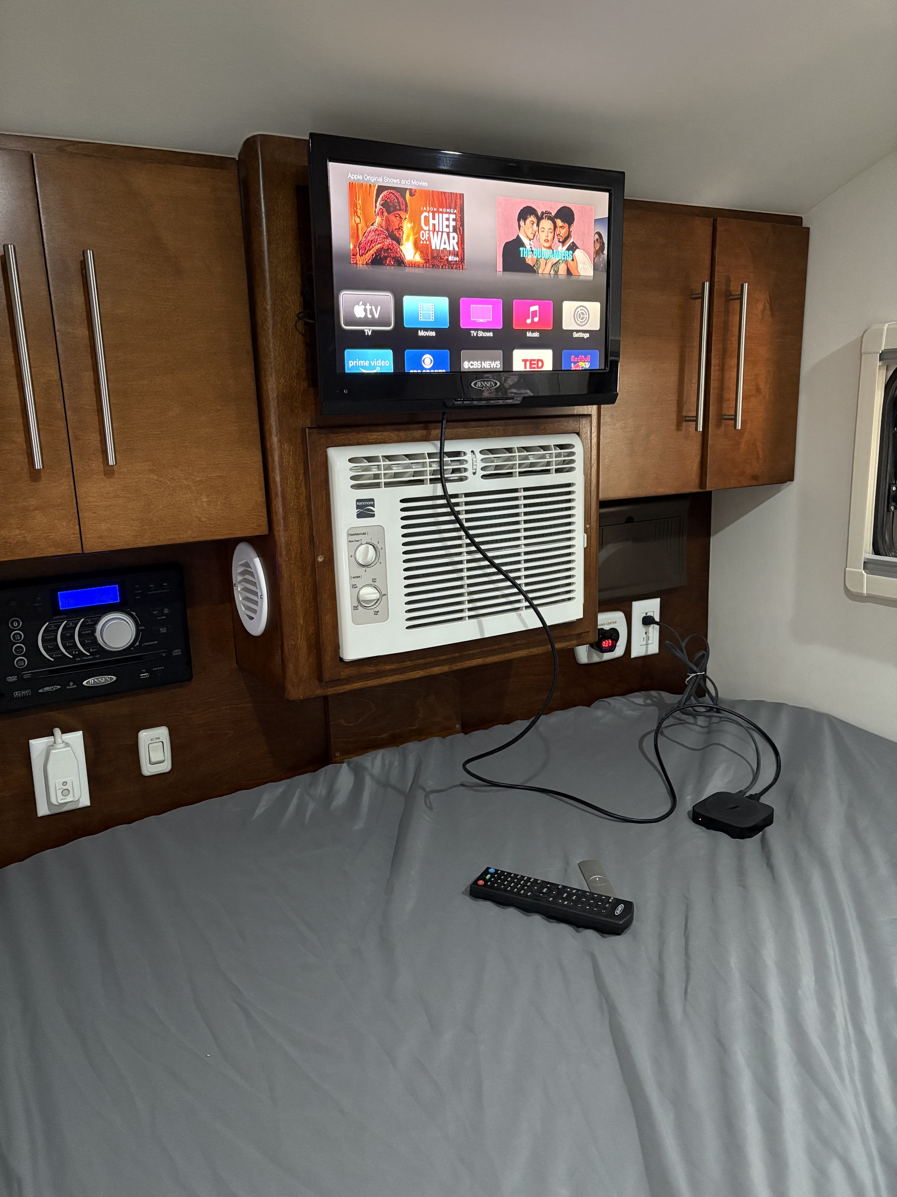 Cozy rv rental bedroom equipped with a mounted TV (Apple TV), AC, & Jensen stereo for ultimate comfort on the road.. T@G Classic 2016