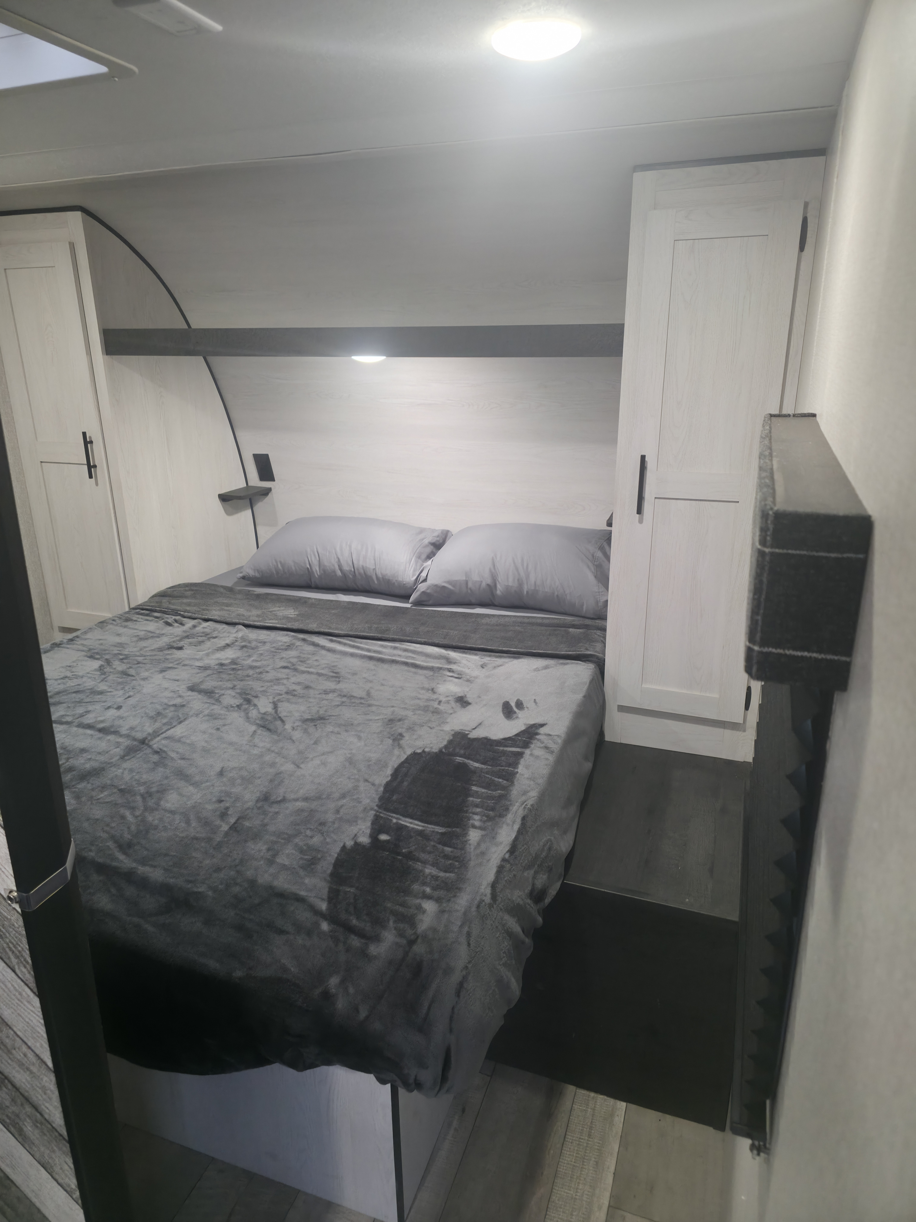 Step into comfort: This RV rental bedroom offers a cozy bed, ample storage in light wood cabinets, and integrated lighting.. KZ 271BHKSE 2022