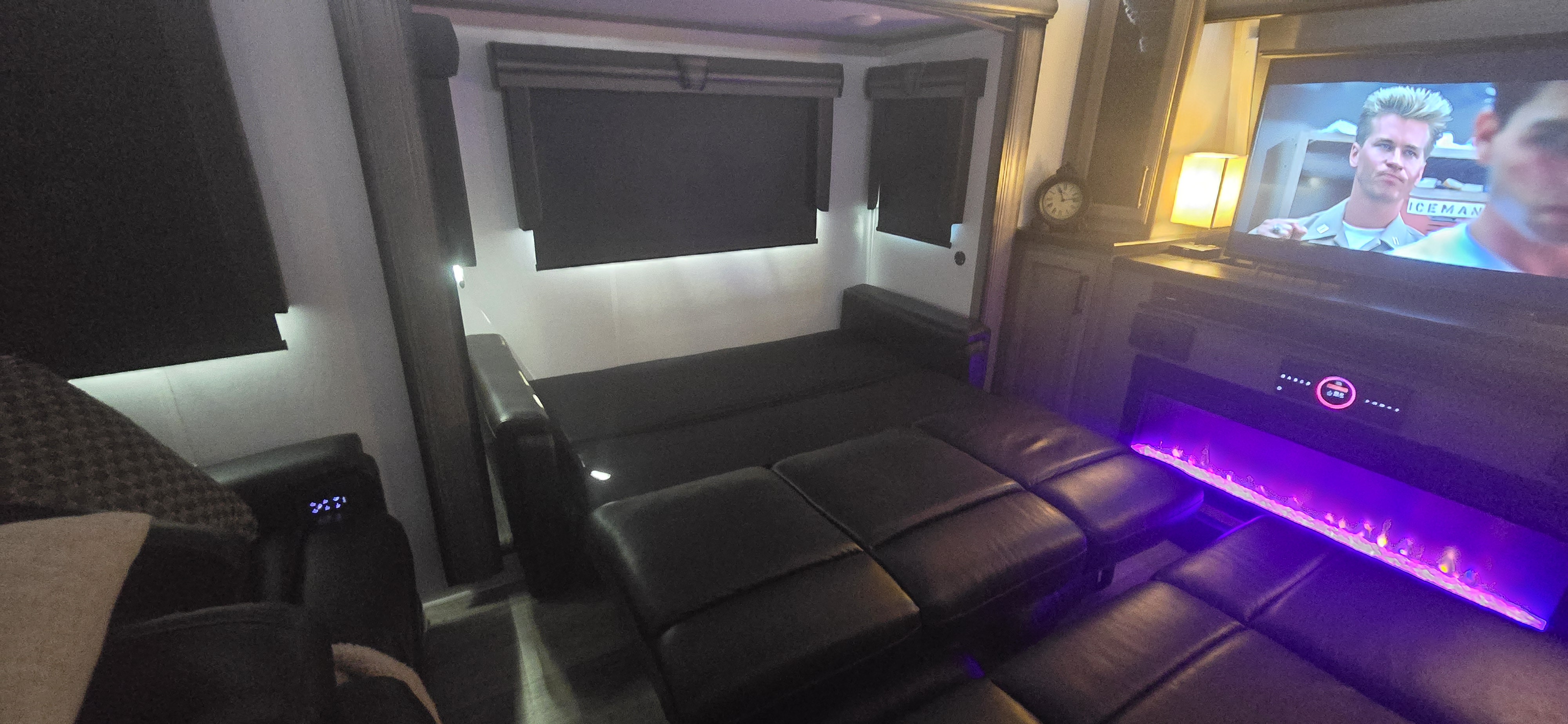 Relaxing RV rental interior: sofa transforms to bed, TV, fireplace with purple lights, and ambient lighting.. Keystone RV Montana 2023