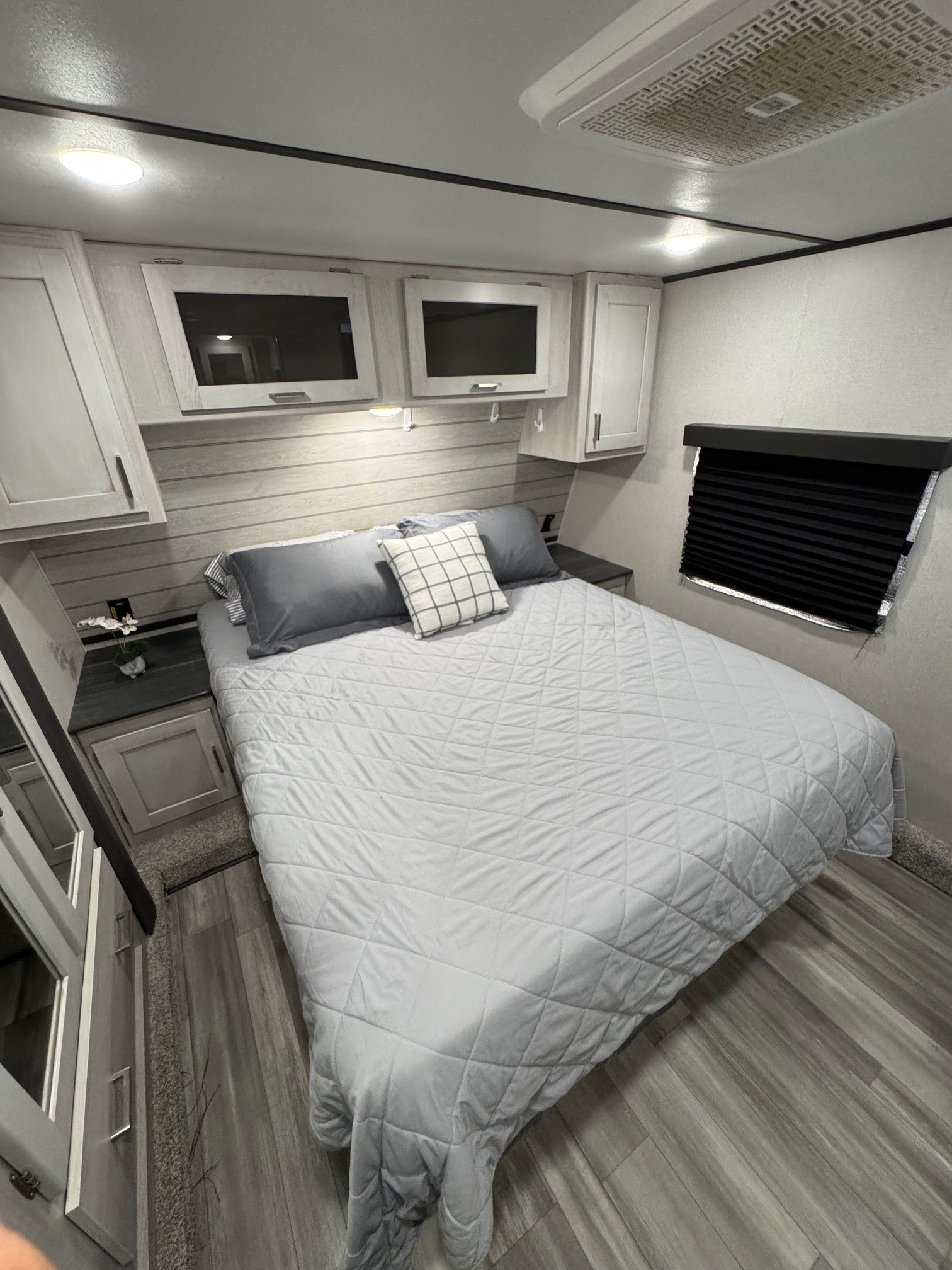 Comfortable RV rental bedroom with modern grey decor, ample storage, and soft lighting for a cozy sleep.. Keystone RV Sprinter 2022