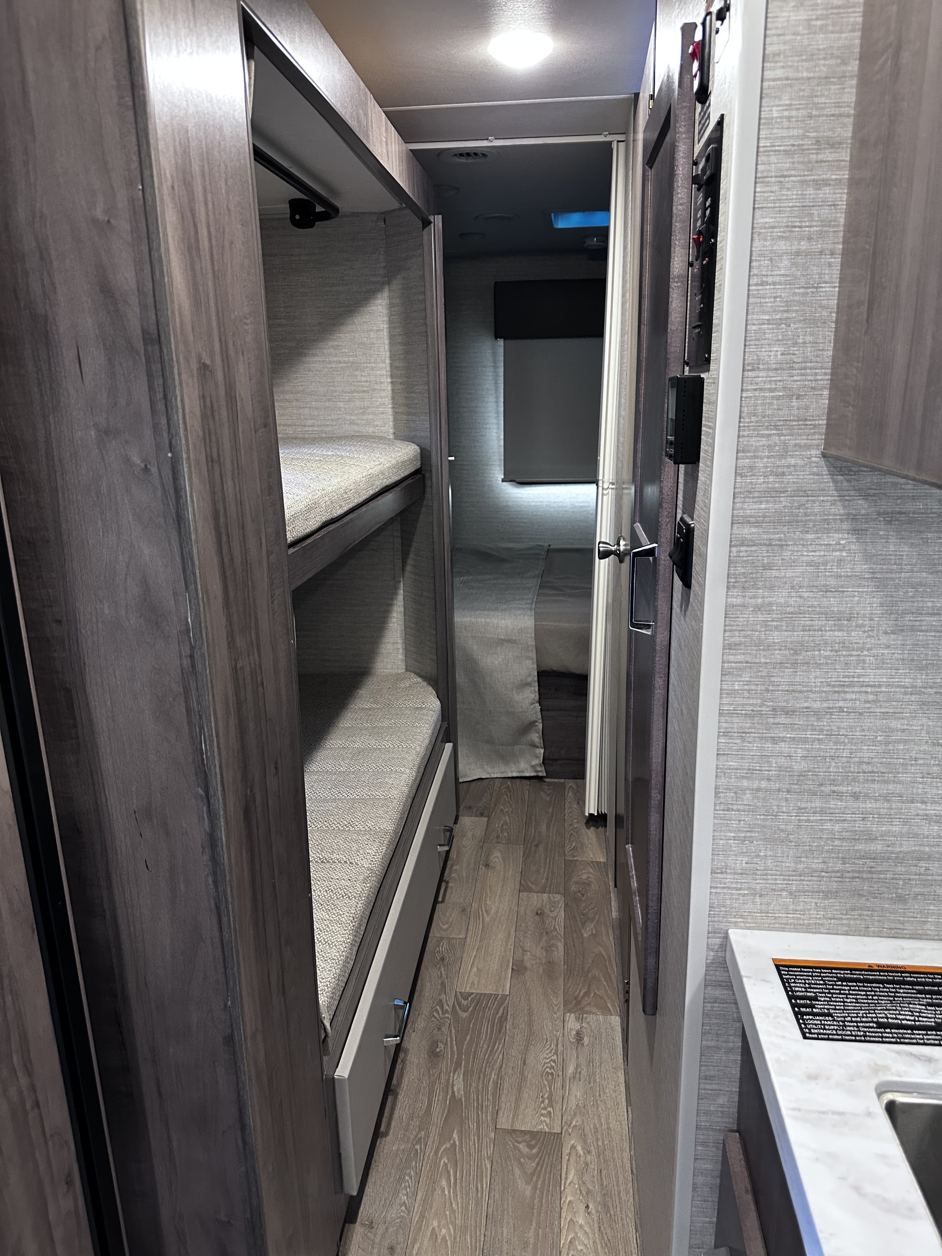 RV rental interior: bunk beds, hallway, and controls. A compact, functional living space for your adventure.. Winnebago Minnie Winnie 2026