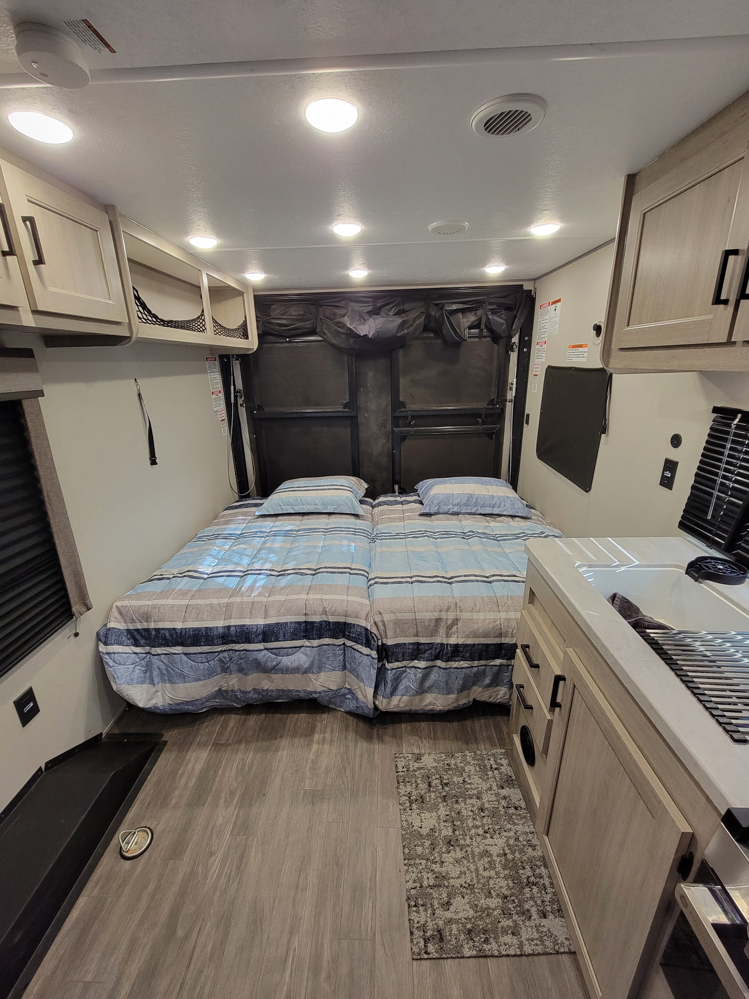 RV rental's versatile interior with twin beds, compact kitchen, and overhead storage, designed for comfortable travel.. Forest River Aurora Aurora Toy Hauler 2025