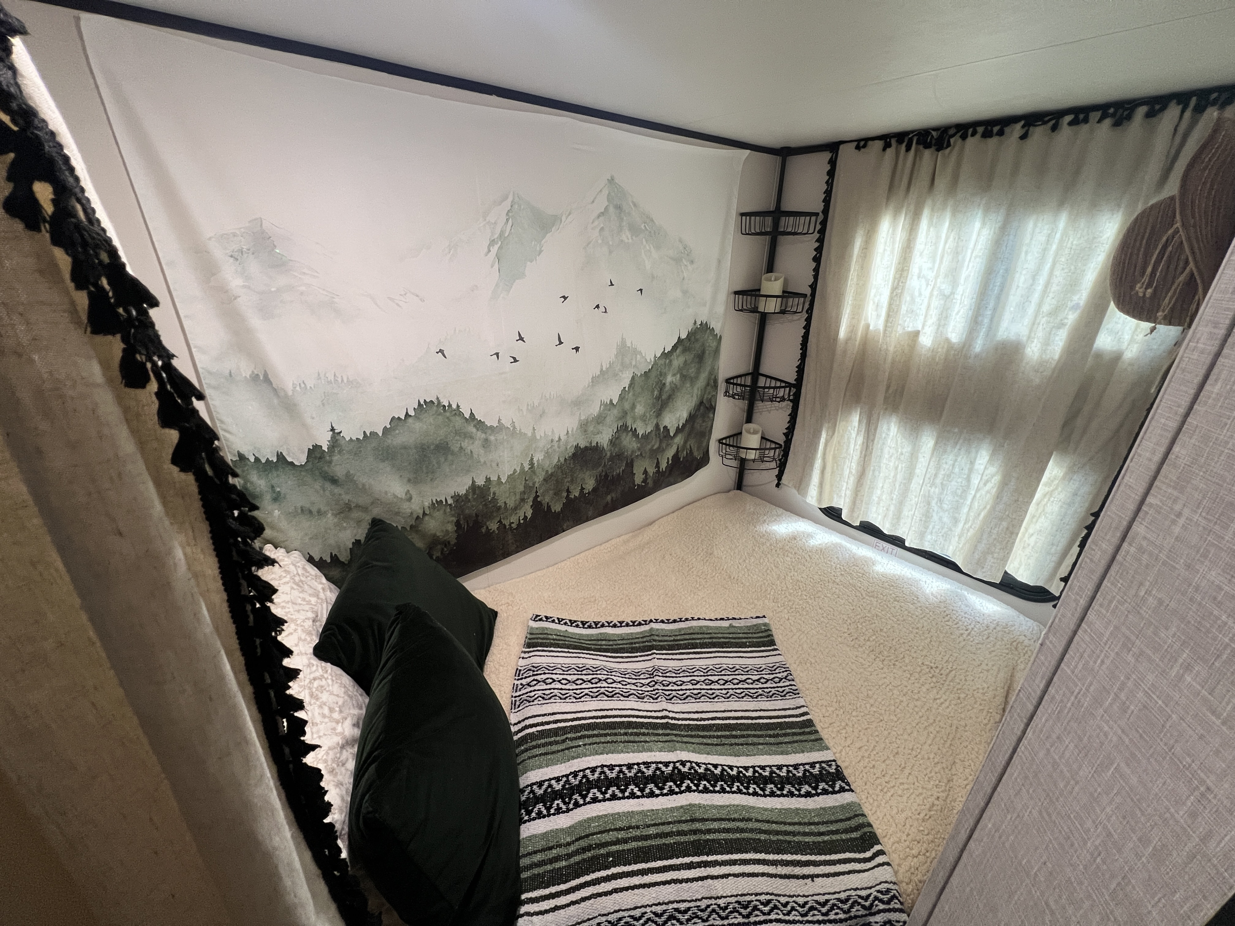 RV rental: Cozy sleeping nook with a mountain tapestry, fluffy bedding, and convenient corner shelves.. Jayco Jay Flight 2024