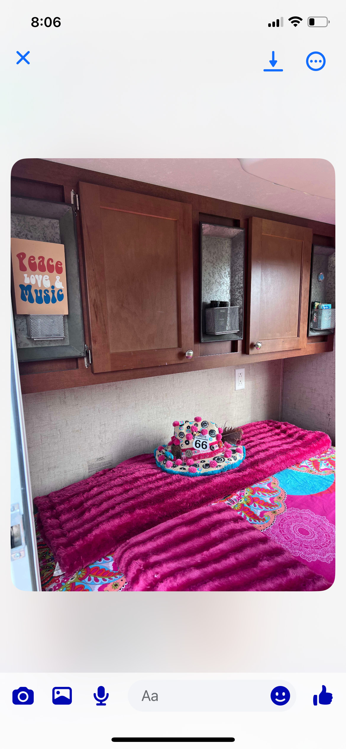 Inside a colorful **RV rental**: bright pink bed with Route 66 hat, wood cabinets, and a 'Peace Love & Music' sign.. Riverside Travel Trailer Retro Jr. 2017