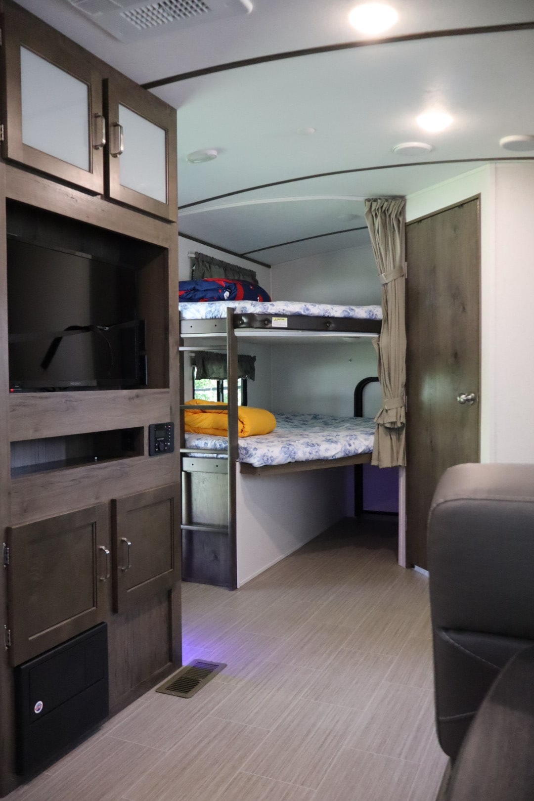 RV rental interior with cozy bunk beds and an entertainment center. A spacious, modern layout ideal for family trips.. Keystone RV Passport Grand Touring 2020