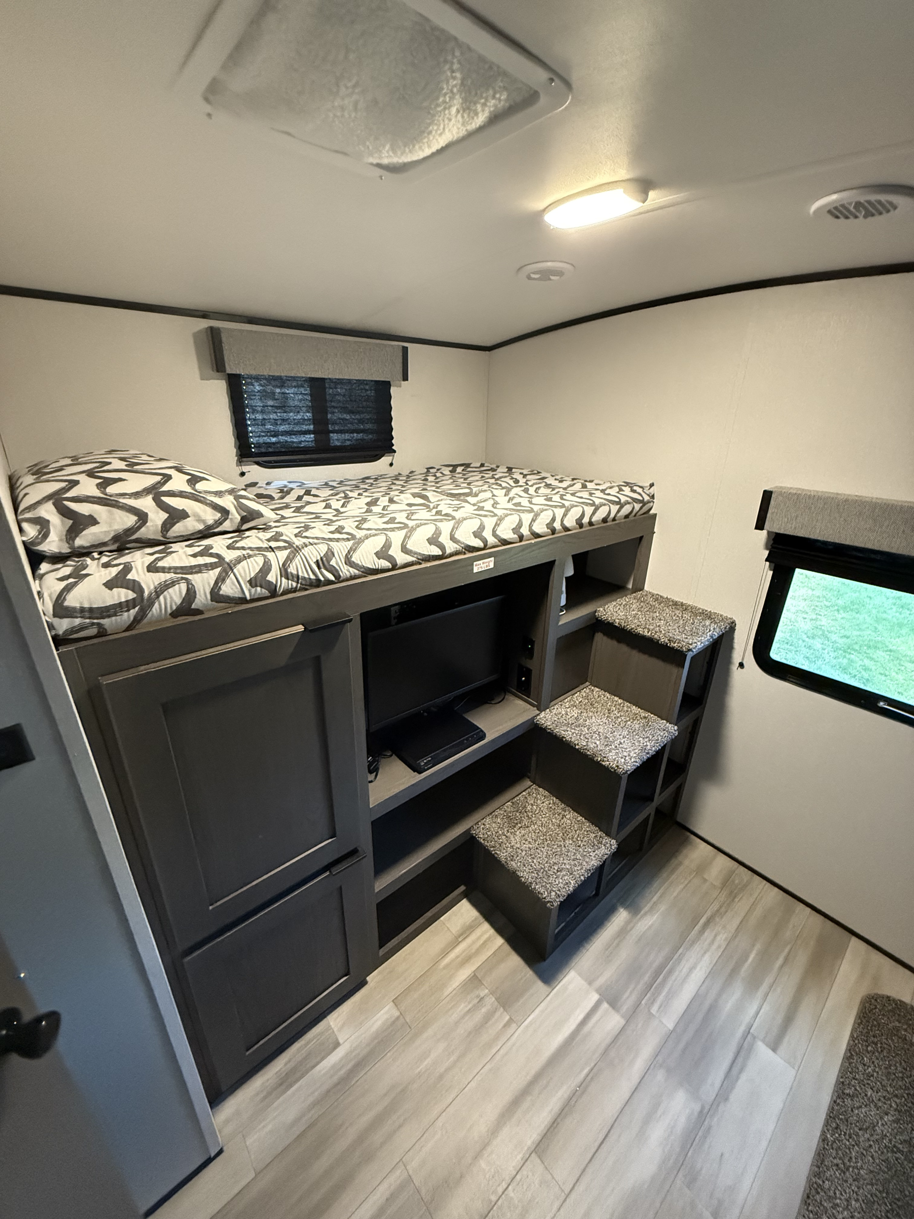 Compact bunk beds in an RV rental, featuring built-in steps, TV, and storage. Ideal for family adventures.. Other Other 2021