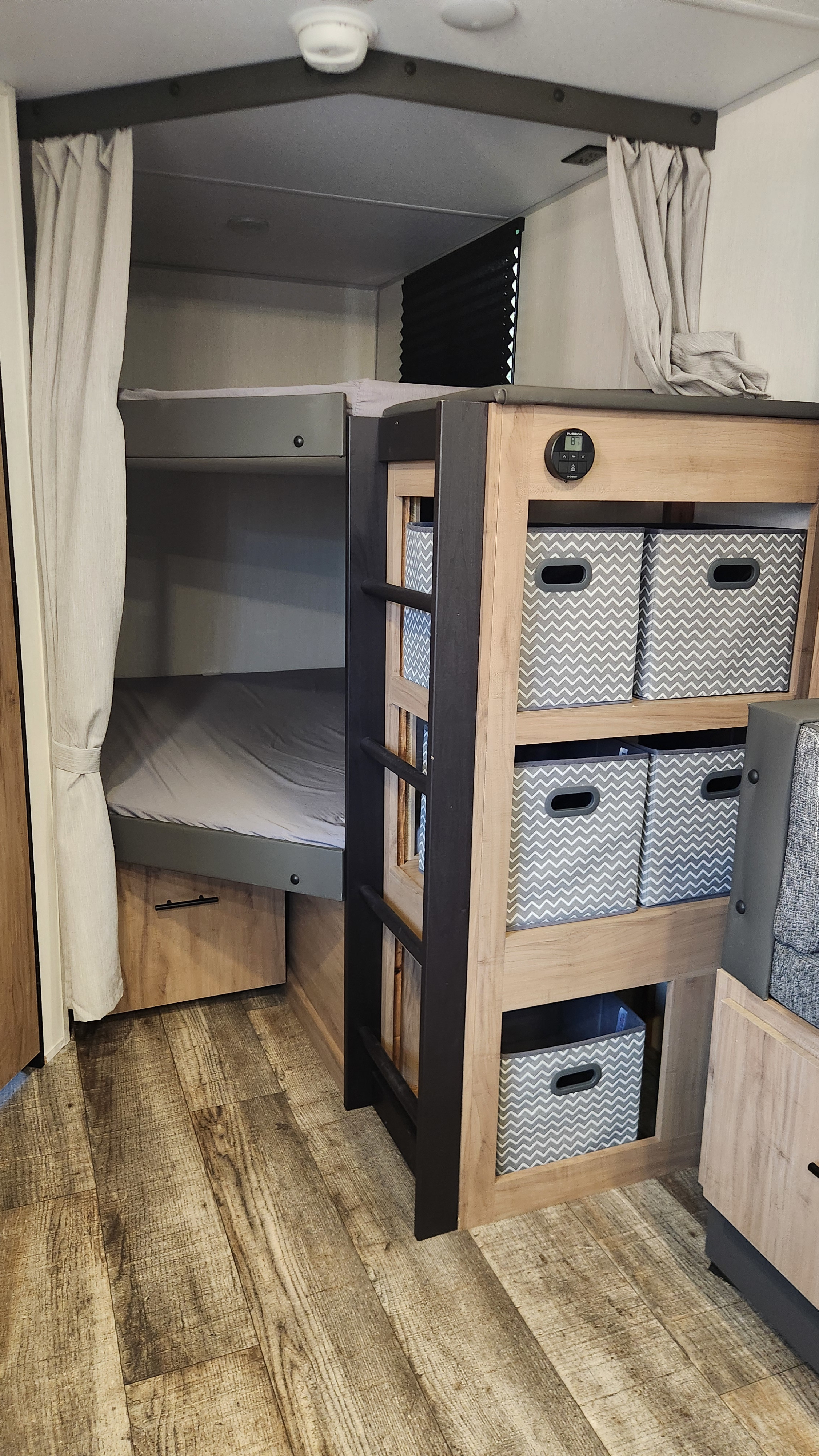 RV rental bunk beds and a storage unit filled with chevron bins. Features wood flooring and a digital display.. Forest River Campsite Reserve 26cj 2025