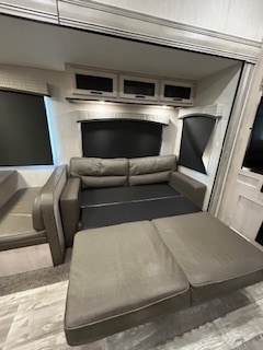 Comfortable RV rental interior featuring a sofa pulled out as a bed, ideal for flexible sleeping arrangements on your trip.. Forest River Sandpiper 2022