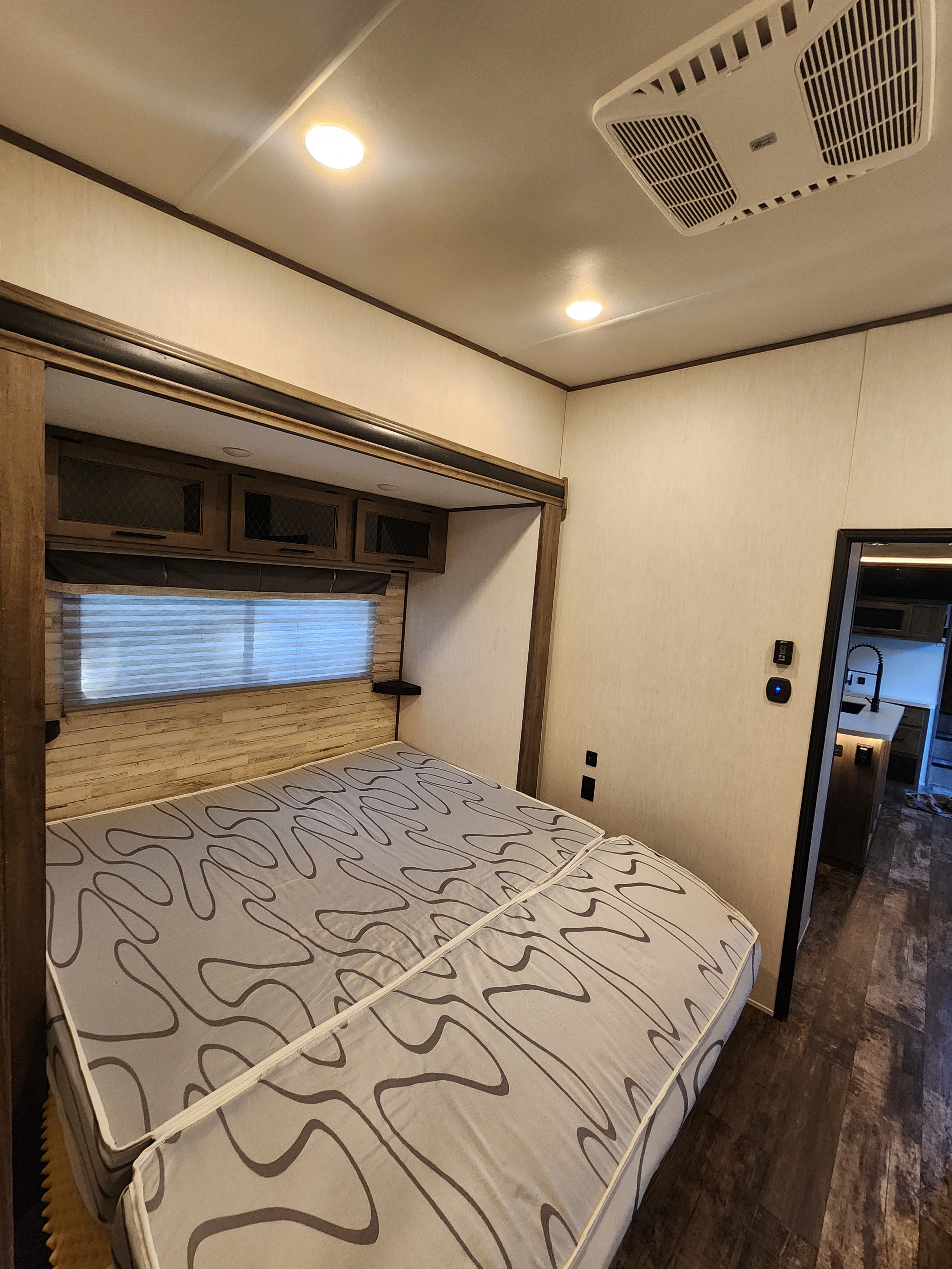 RV rental bedroom interior features: convertible bed, overhead storage, and ceiling AC. Cozy and functional.. Forest River Sabre 2022