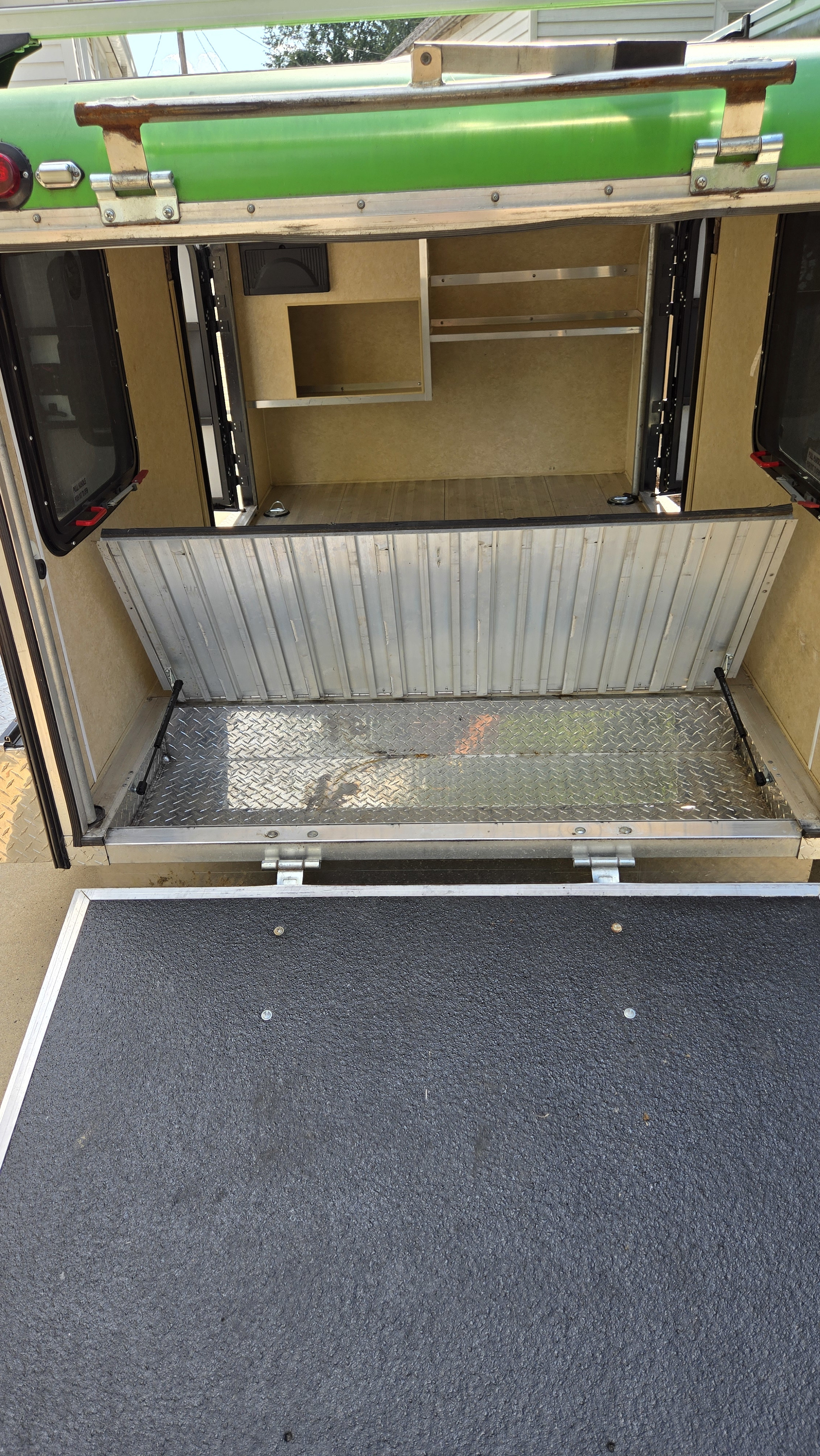 RV rental: Rear access of green camper, revealing fold-down aluminum ramp, interior shelving, and diamond plate floor.. Micro-Lite Cargo-light ag 2013