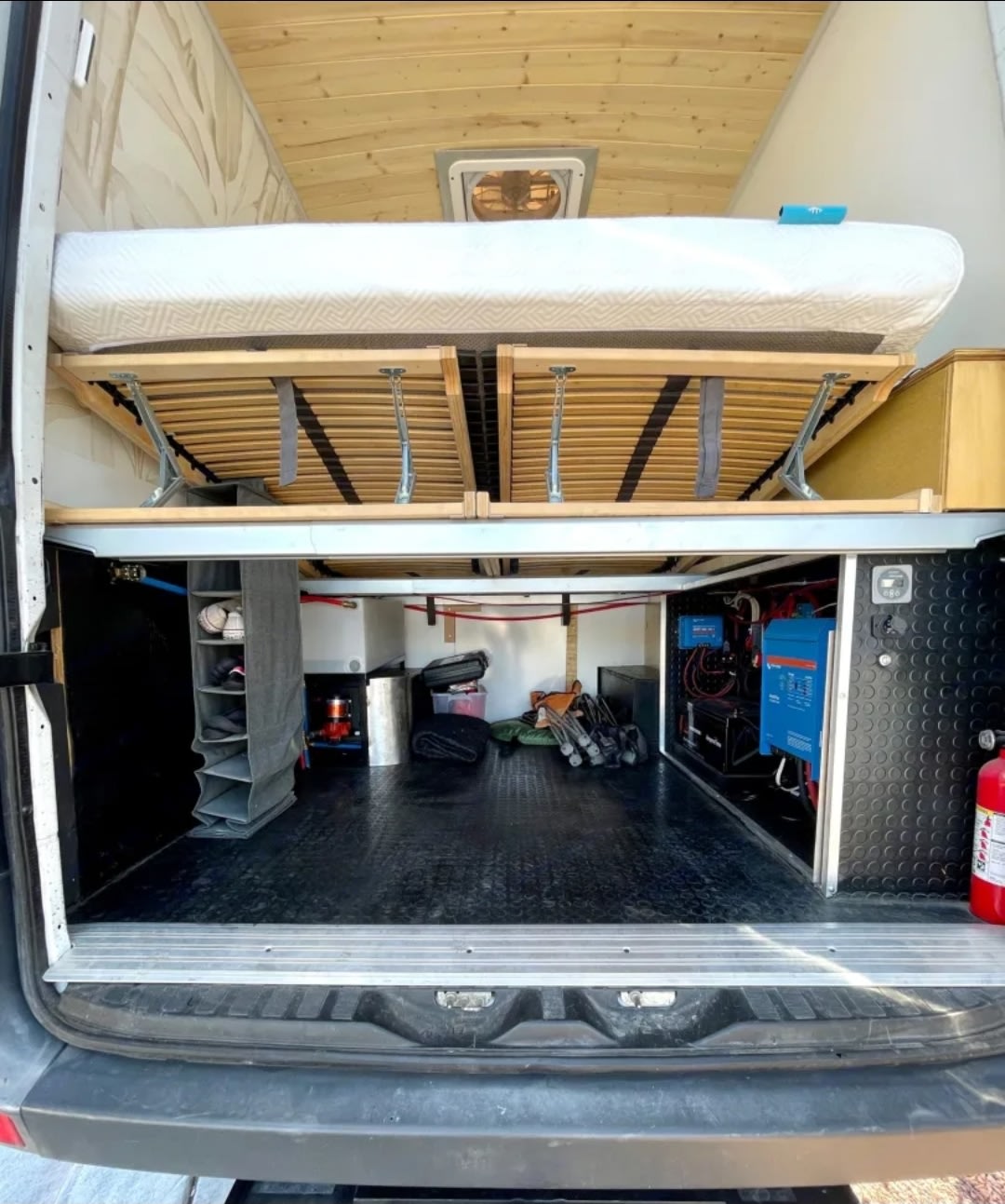 RV rental van conversion: Elevated bed, spacious storage below, and integrated electrical/water systems. A well-equipped camper van.. Mercedes Sprinter 2012
