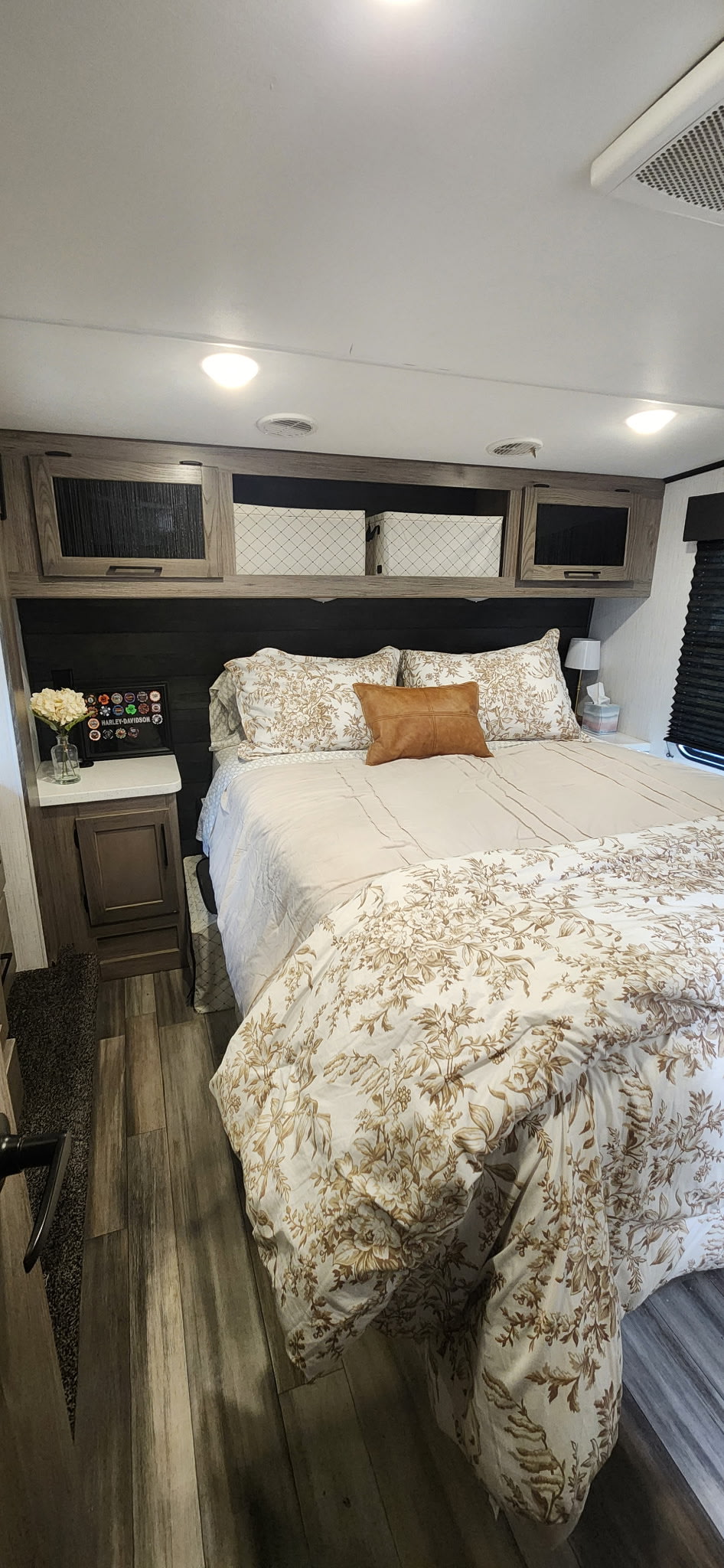 Comfortable RV rental bedroom with floral bedding, nightstands, and practical overhead storage cabinets.. Heartland RVs Fuel Toy Hauler 2022
