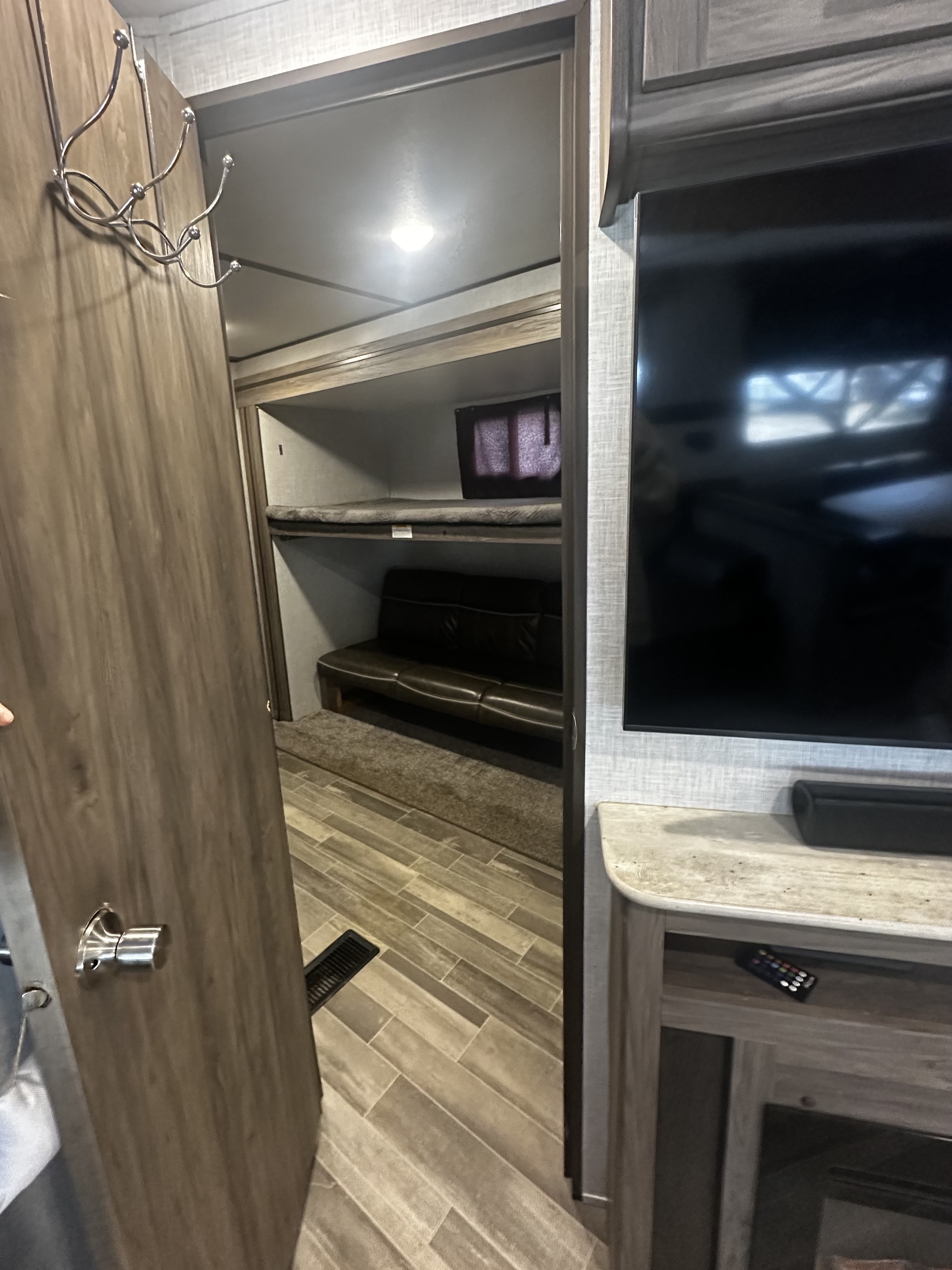 Step inside this RV rental! Features include a cozy bunkhouse with a couch, entertainment center with TV, and modern flooring.. Crossroads RV Zinger 2020