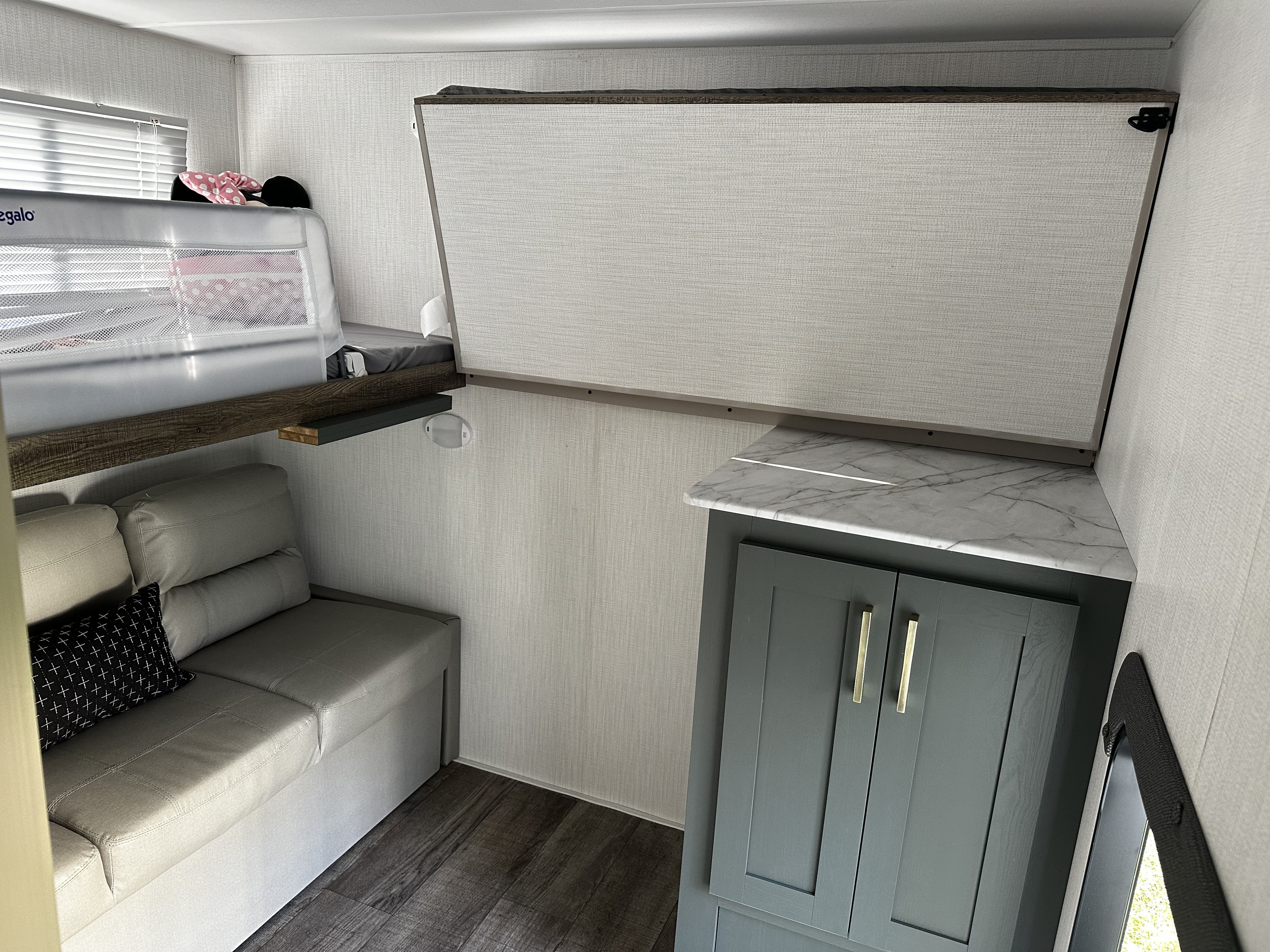 RV rental interior featuring a clever bunk bed design, comfy sofa, and stylish counter/cabinet space for family travel.. Heartland RVs EDDIE BAUER 322BH-C 2024