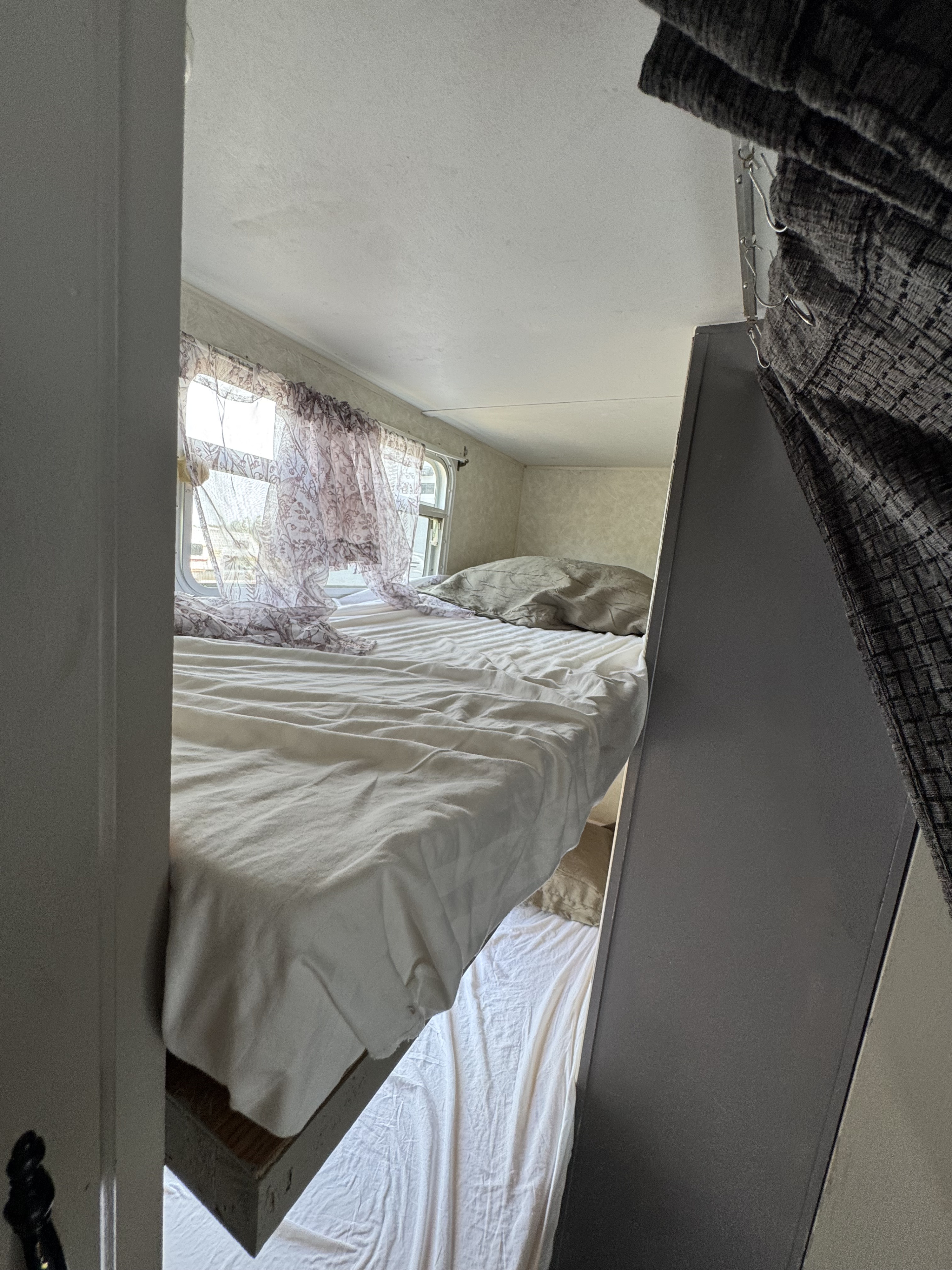 RV rental interior: cozy bunk beds with floral curtains and window, offering compact sleeping space.. SALEM Travel Trailer 2005