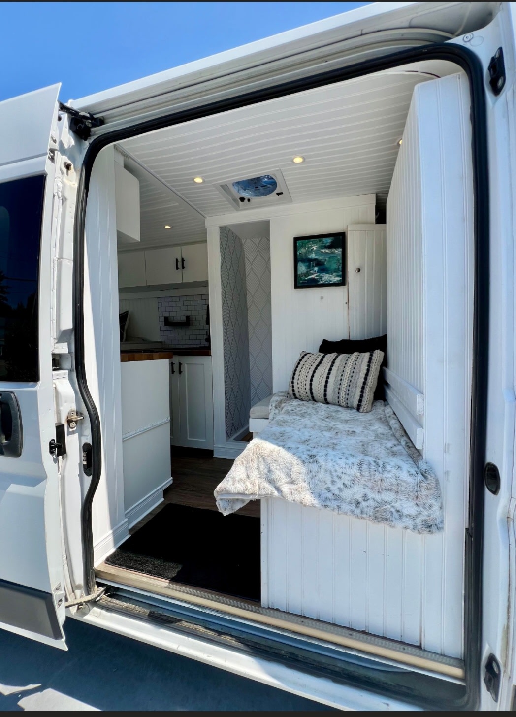 Inside a bright rv rental: a modern camper van living space with a comfy bench, compact kitchen, and stylish details.. Dodge Promaster 3500 Extended 2019