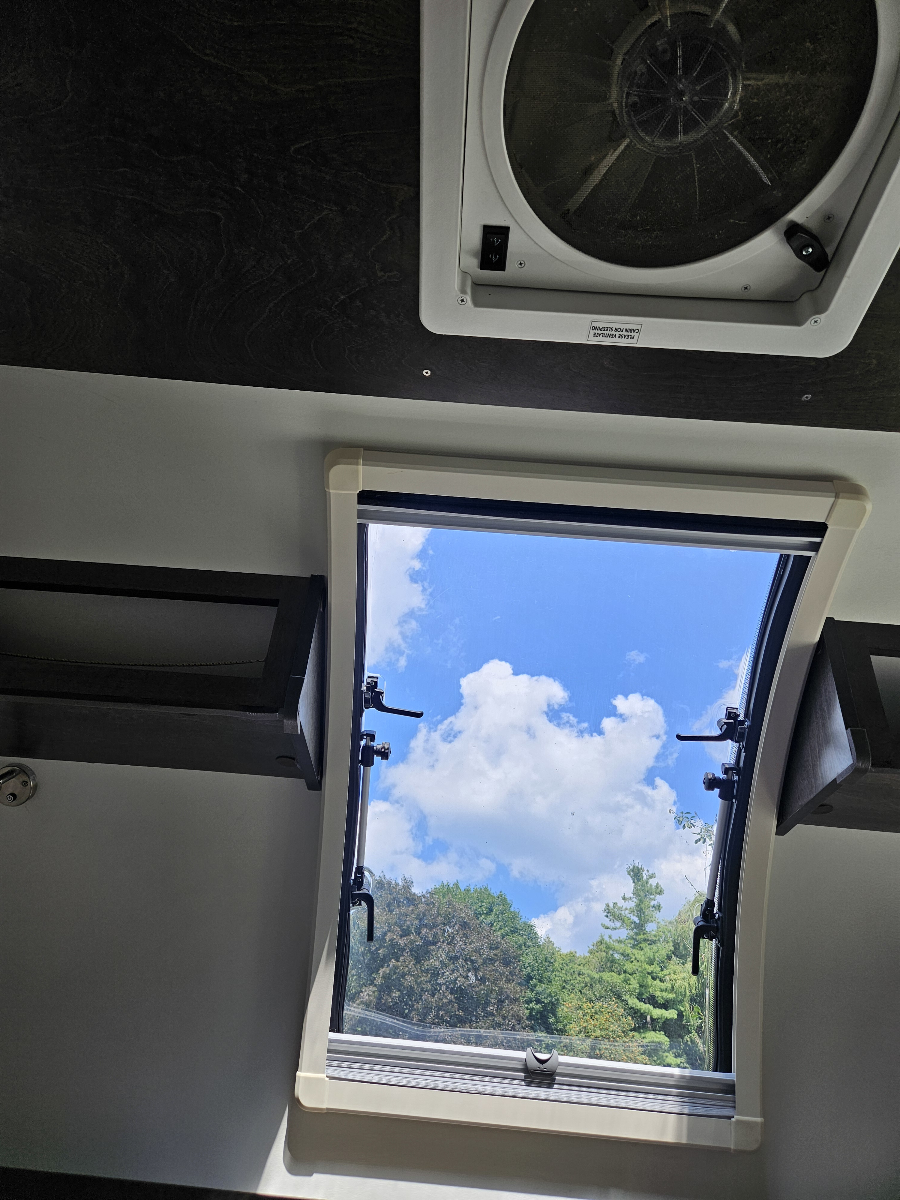 RV rental: Open window with blue sky & trees from inside, plus a ceiling fan.. nuCamp T@G 2021