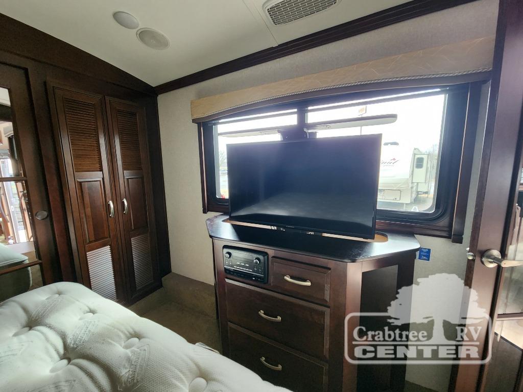 RV rental interior: Bedroom with TV, dresser, wardrobe, and comfortable mattress. Ready for adventure.. Jayco Designer 39RE 2017