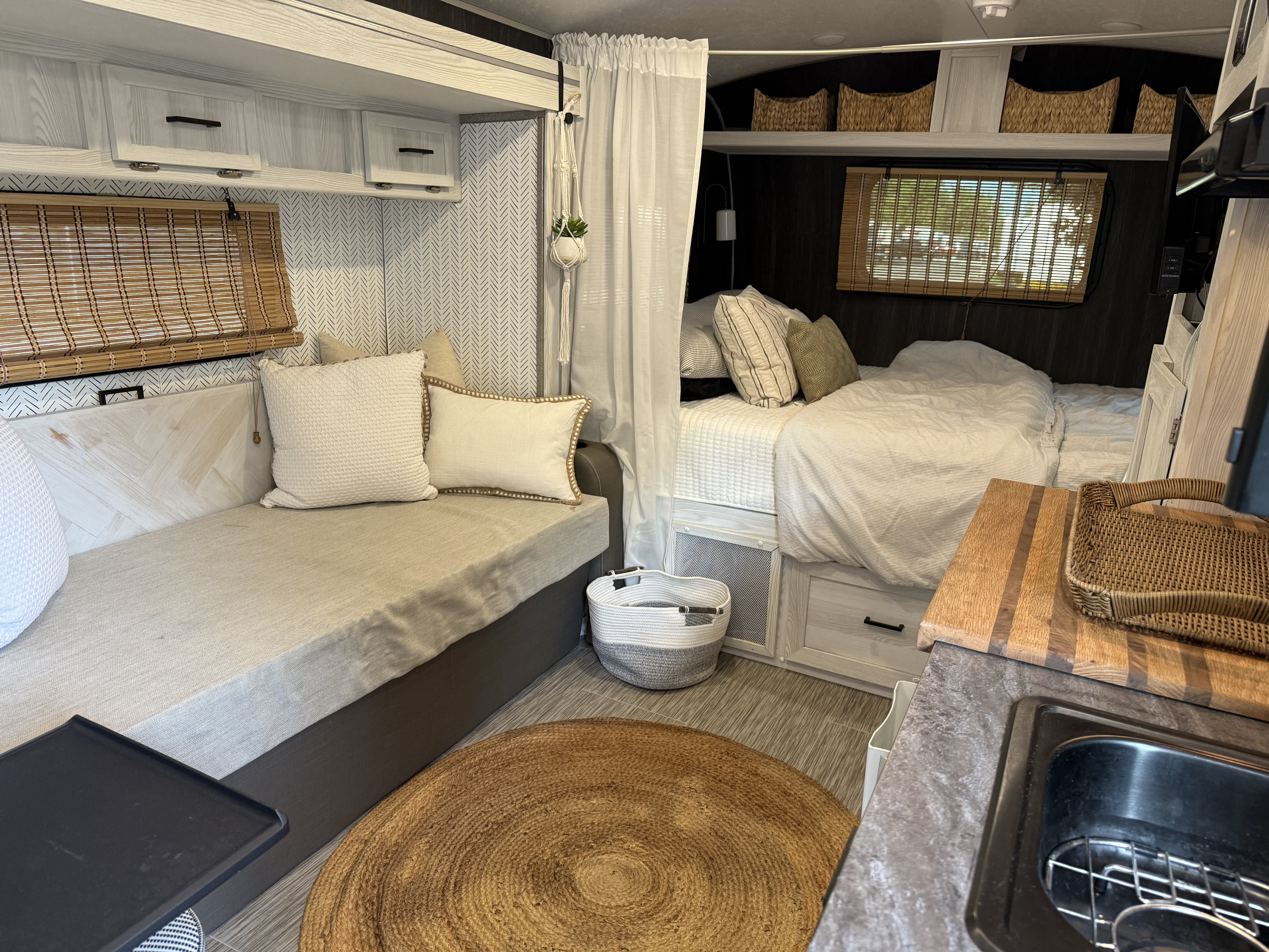 Stylish RV rental interior showcasing a comfortable bed, seating, and a compact kitchen space.. Forest River Rockwood Geo Pro 2019
