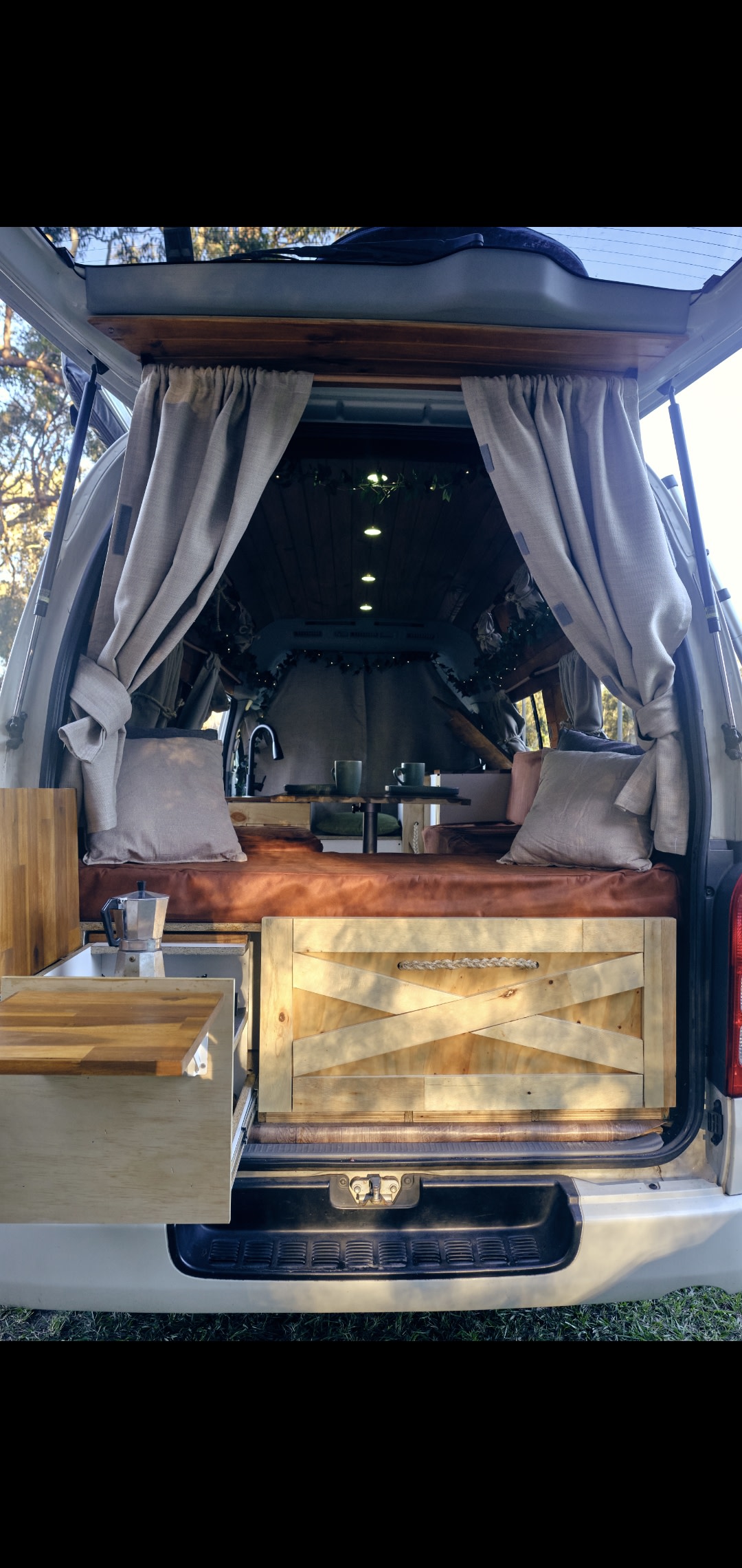 Cozy RV rental interior. Rear view reveals custom wooden storage, bed, sink, and pull-out table, ready for adventure.. Toyota HIACE 2007