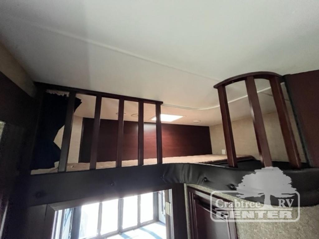 RV rental interior: elevated sleeping loft with wooden railings and a separate bunk area, maximizing space.. Heartland Road Warrior 425 2016