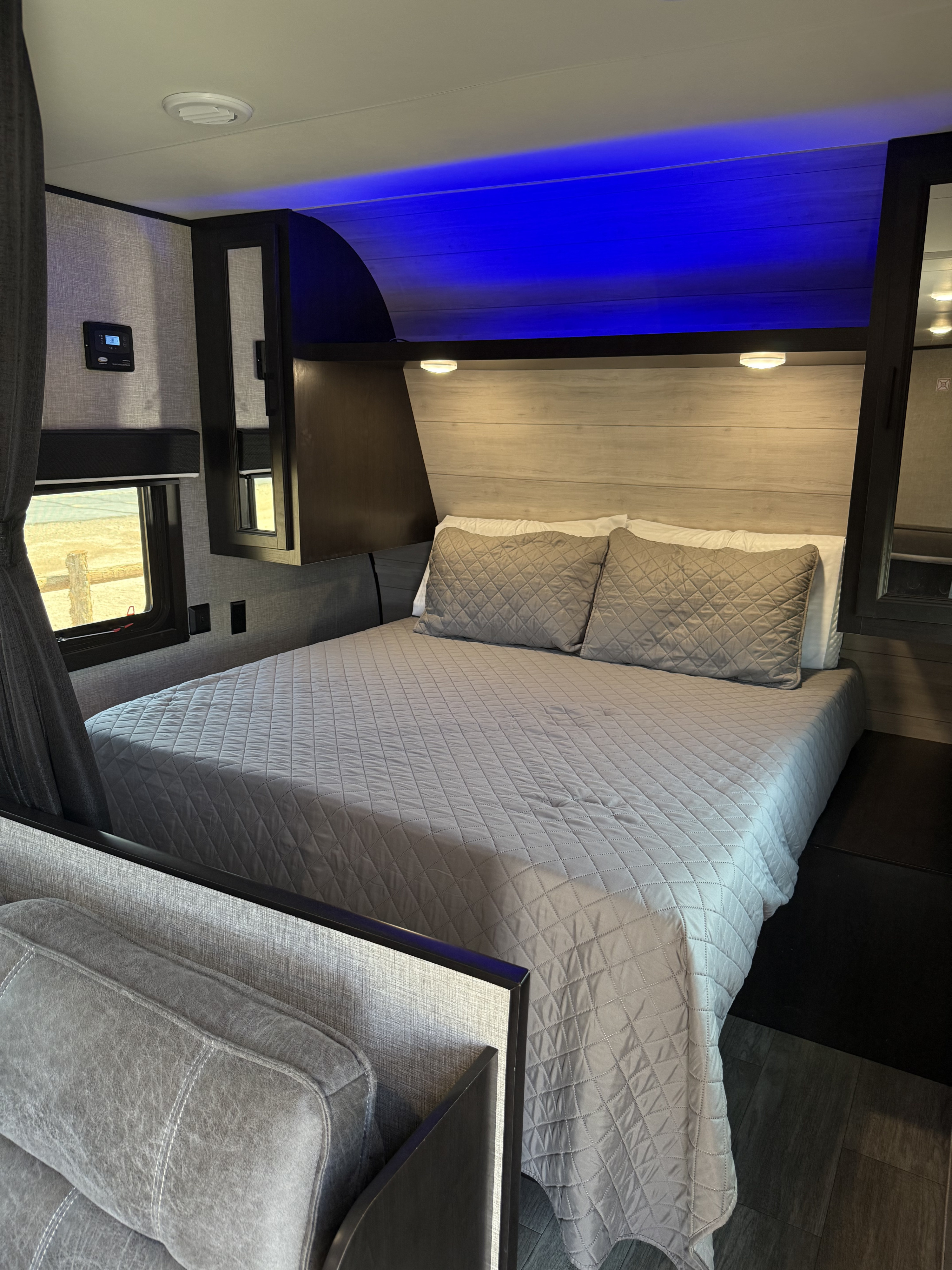 Spacious RV rental bedroom with a comfy bed, blue accent lighting, and modern finishes, perfect for travel comfort.. Jayco Jay Flight SLX 2022