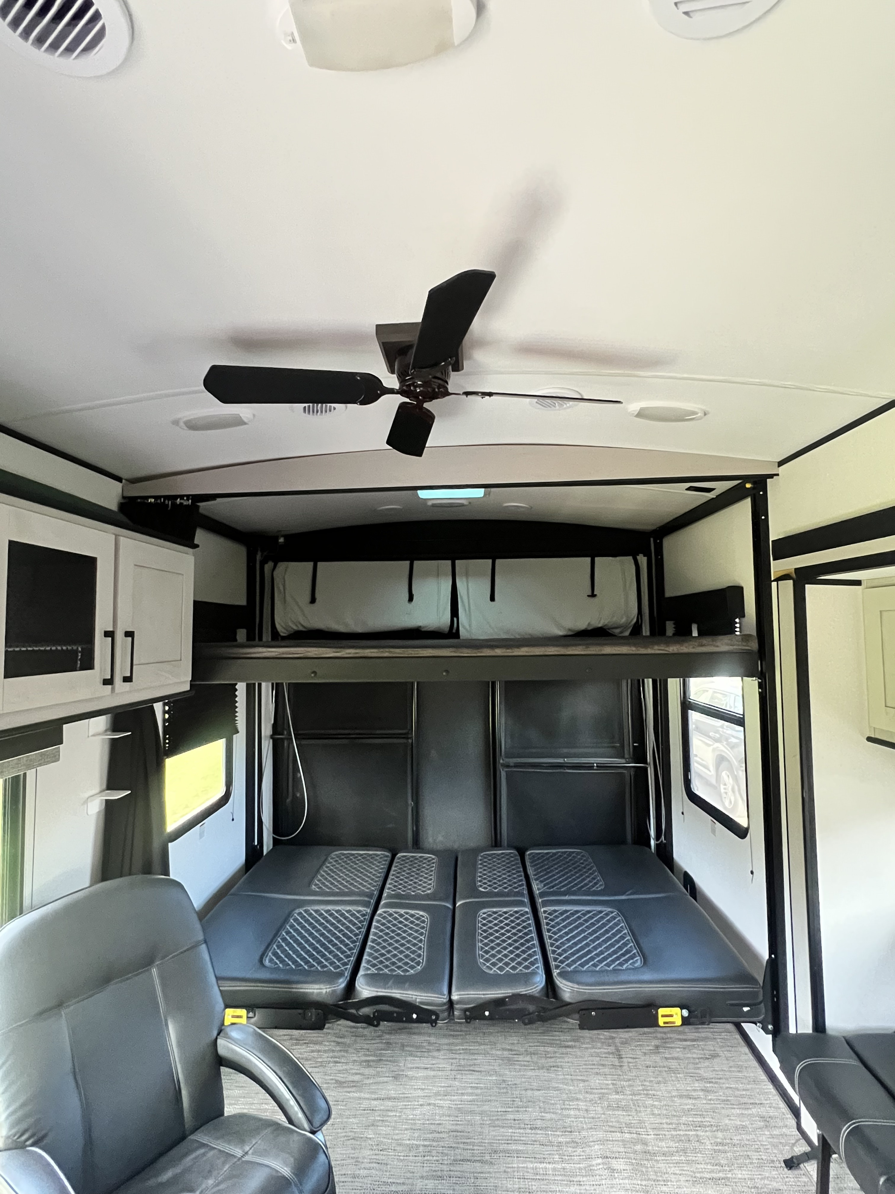 RV rental interior: Spacious toy hauler with convertible lower beds/seating, upper bunk, and ceiling fan for comfort.. Heartland Torque 2021