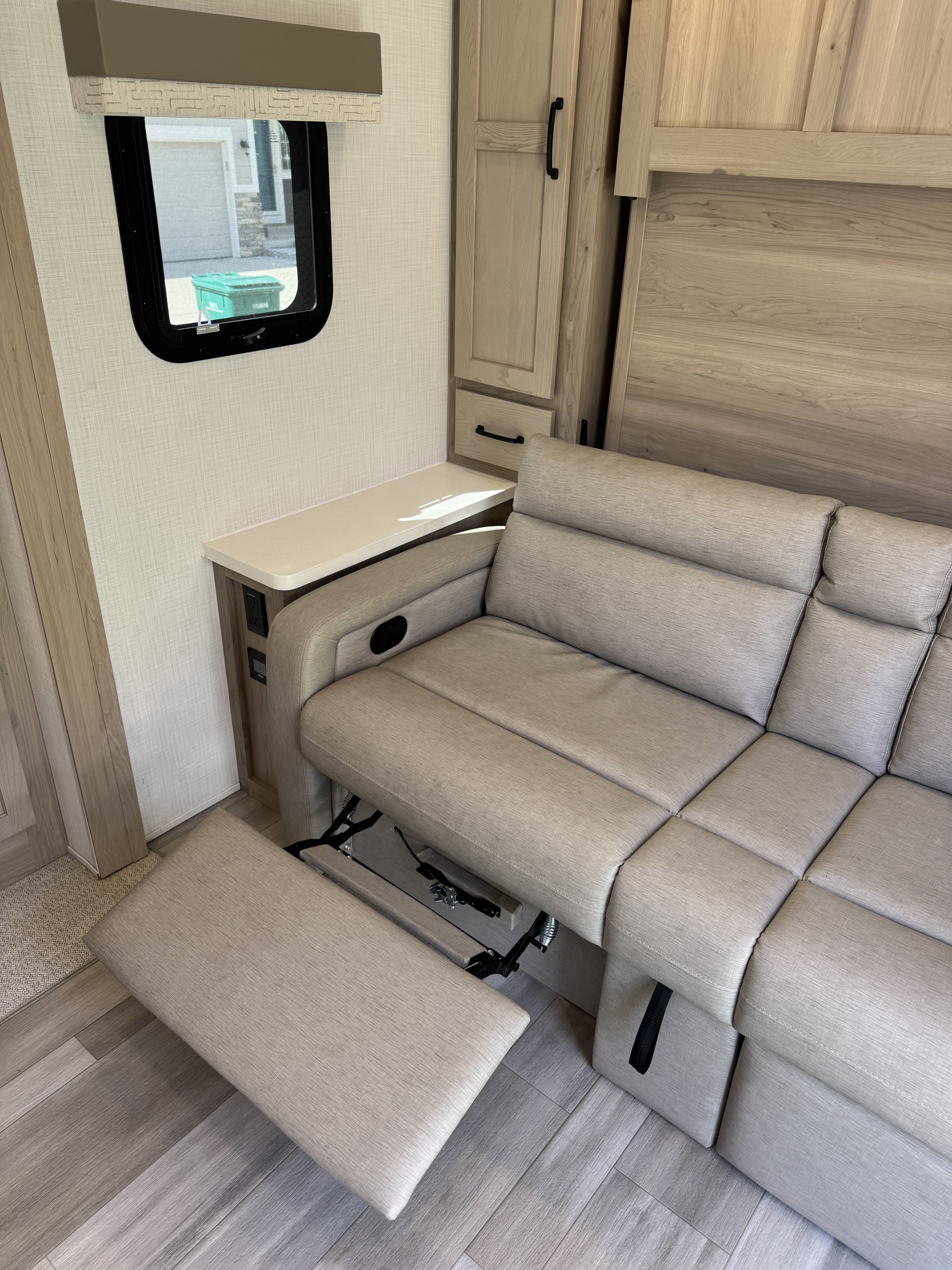 RV rental interior featuring a comfy reclining sofa, smart storage, and a handy side table. Perfect for your next trip!. Forest River Flagstaff Micro Lite 2024