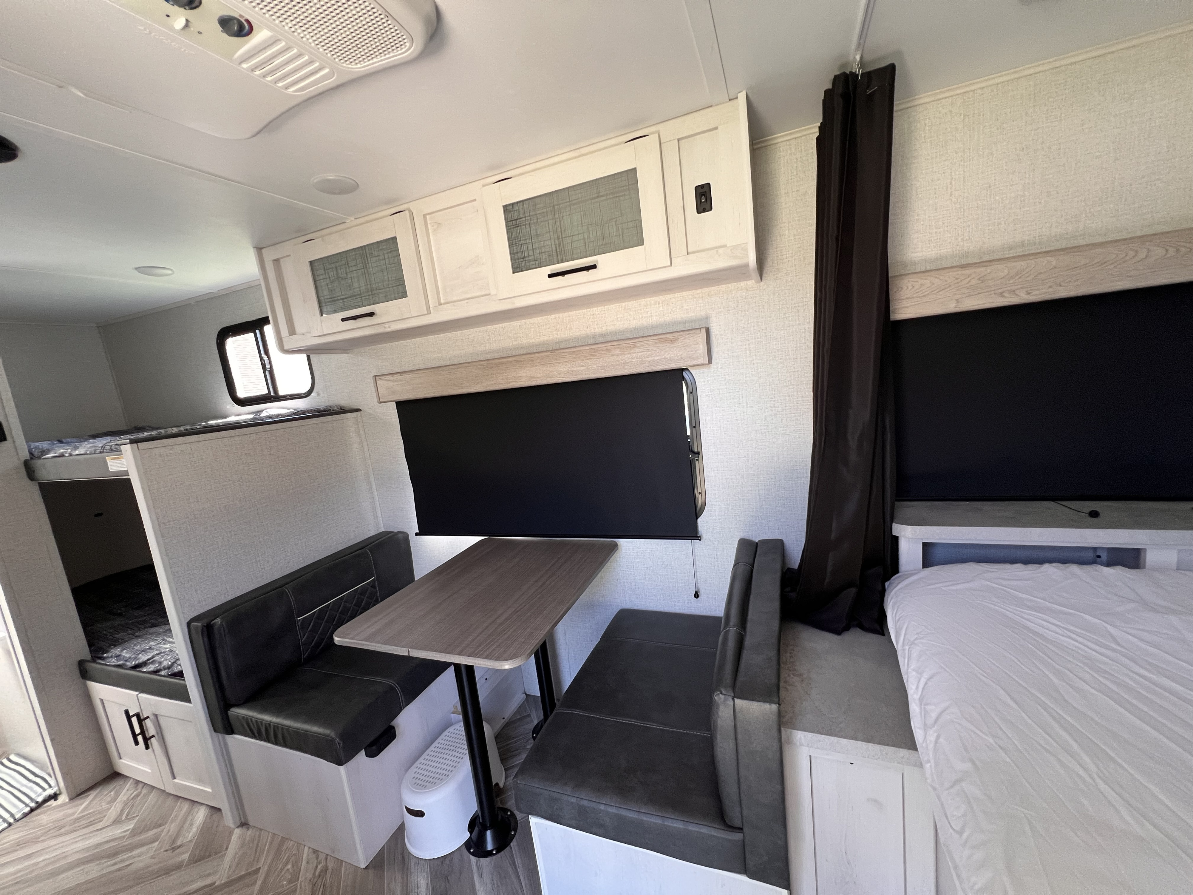 RV rental interior: dinette, bunk beds, main bed, and overhead storage. Ideal for family trips.. Dutchmen Coleman Rubicon 2021