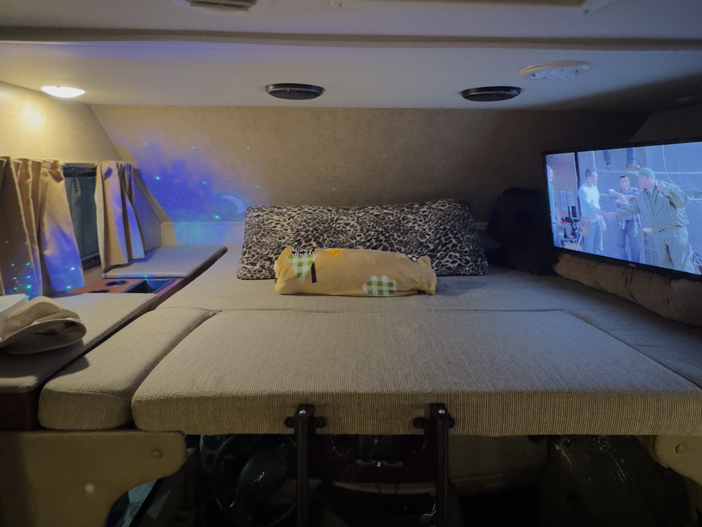 Relax in this cozy rv rental's over-cab bed with a leopard print pillow, TV, and fun ambient lighting for your travel comfort.. Forest River Forester 3171DS 2016