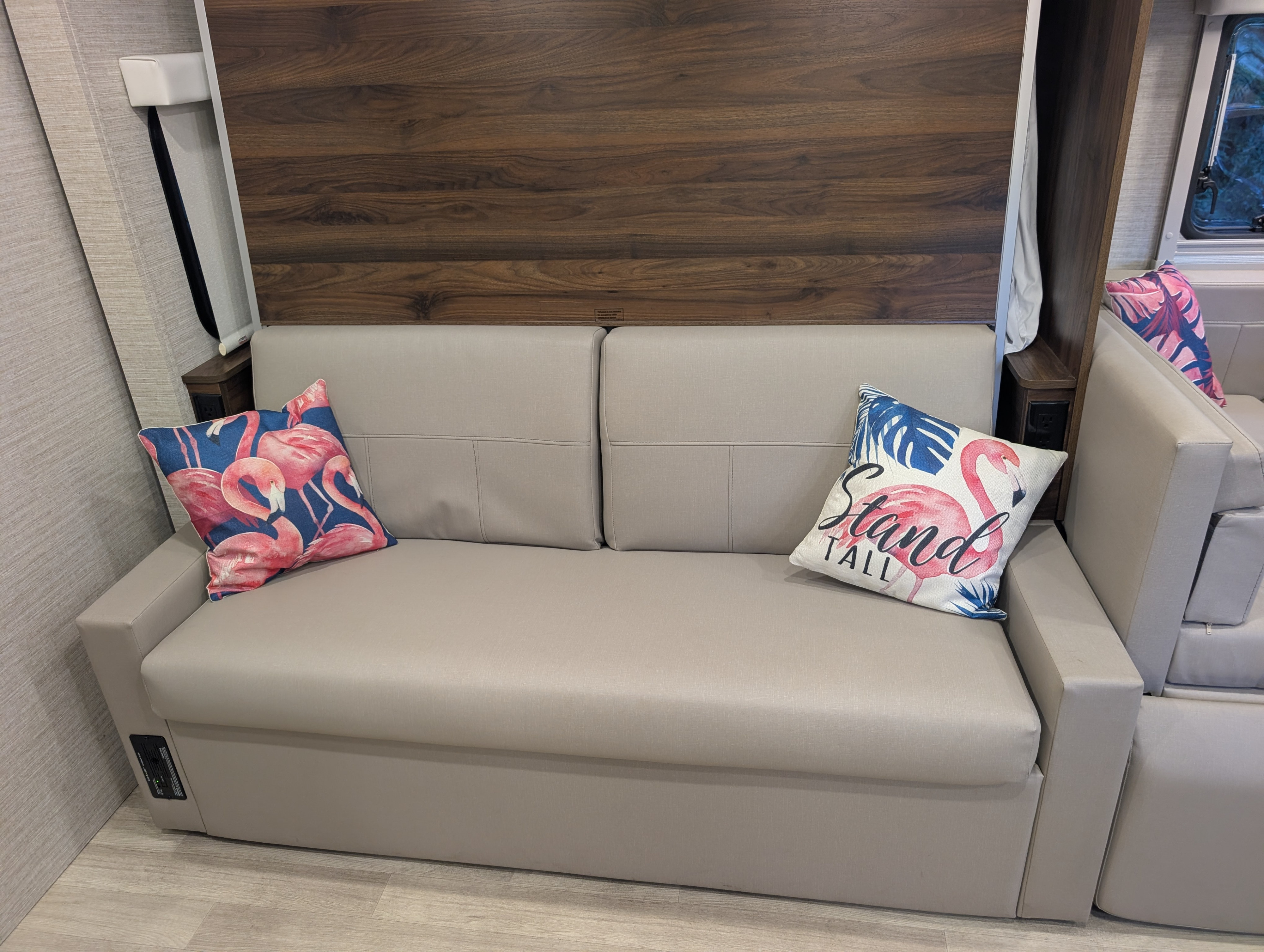 RV rental interior: A modern, comfortable sofa with two vibrant flamingo pillows, offering a cozy spot for your adventures.. Winnebago View 2025