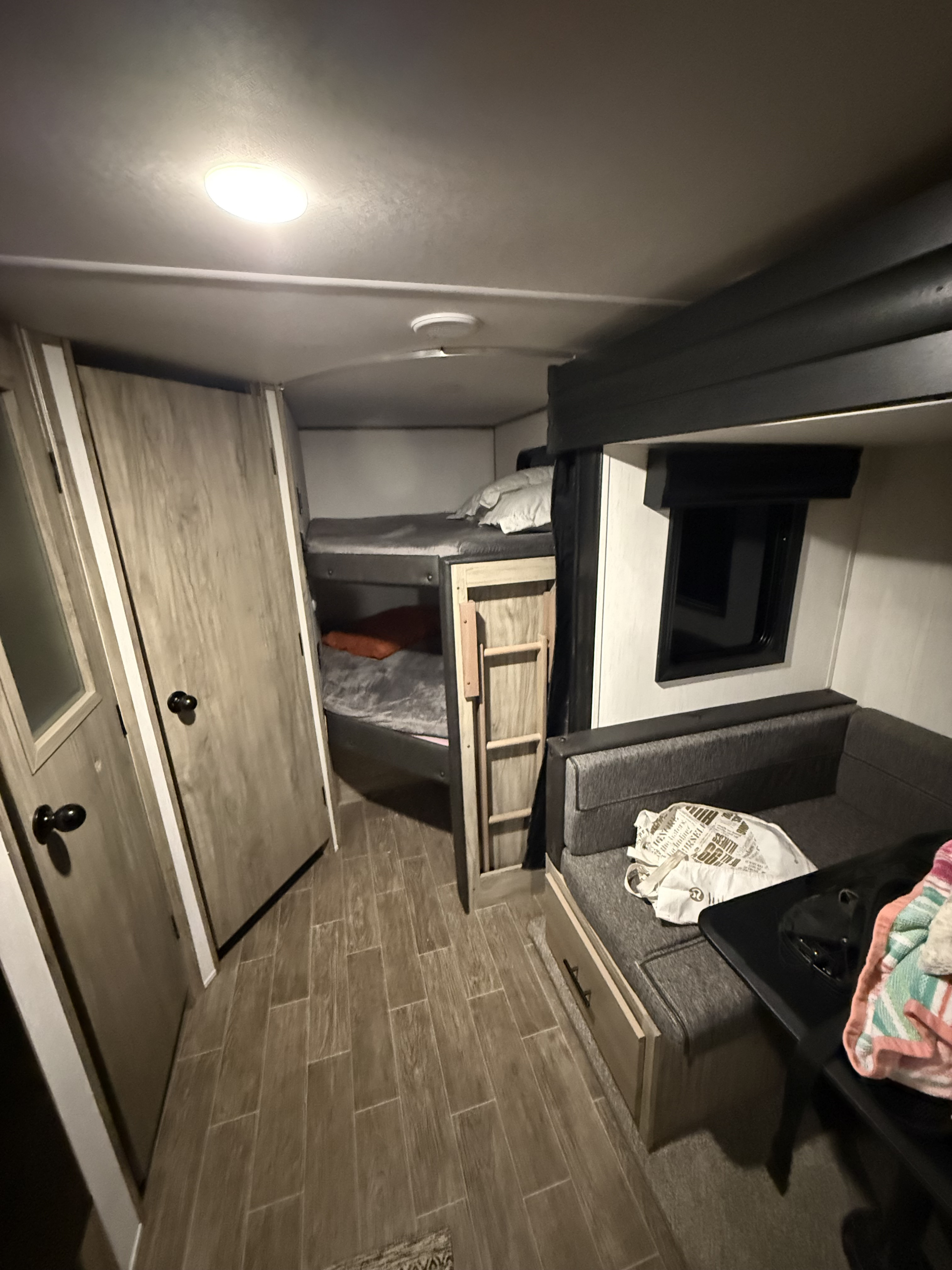 This rv rental's interior features cozy bunk beds, a dinette seating area, and wood-look flooring, ready for your adventure.. Forest River Cherokee Alpha Wolf 2022