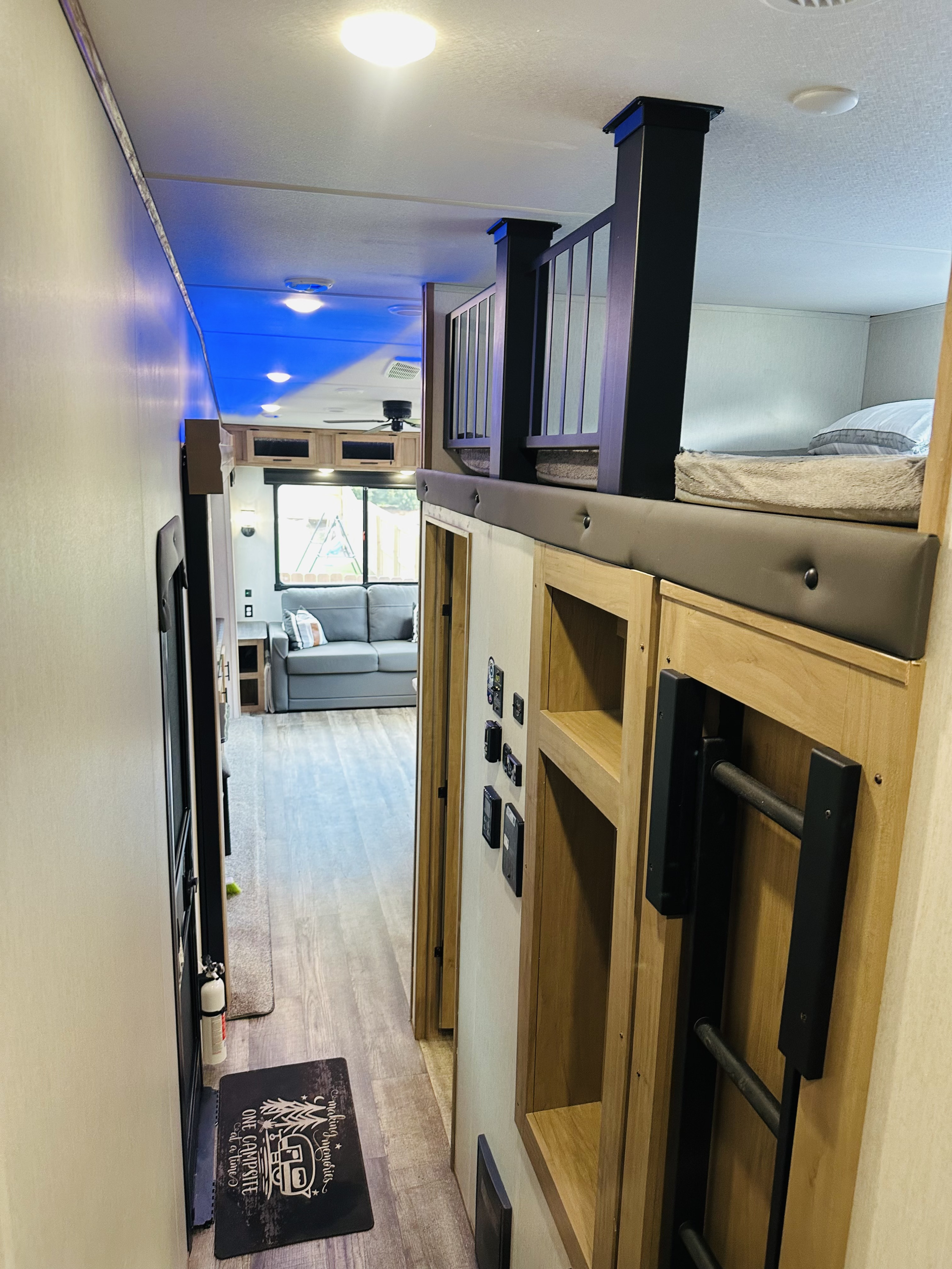 Spacious RV rental interior with a cozy bunk bed area, lounge, and convenient amenities for your journey.. Forest River Cherokee Arctic Wolf 2023
