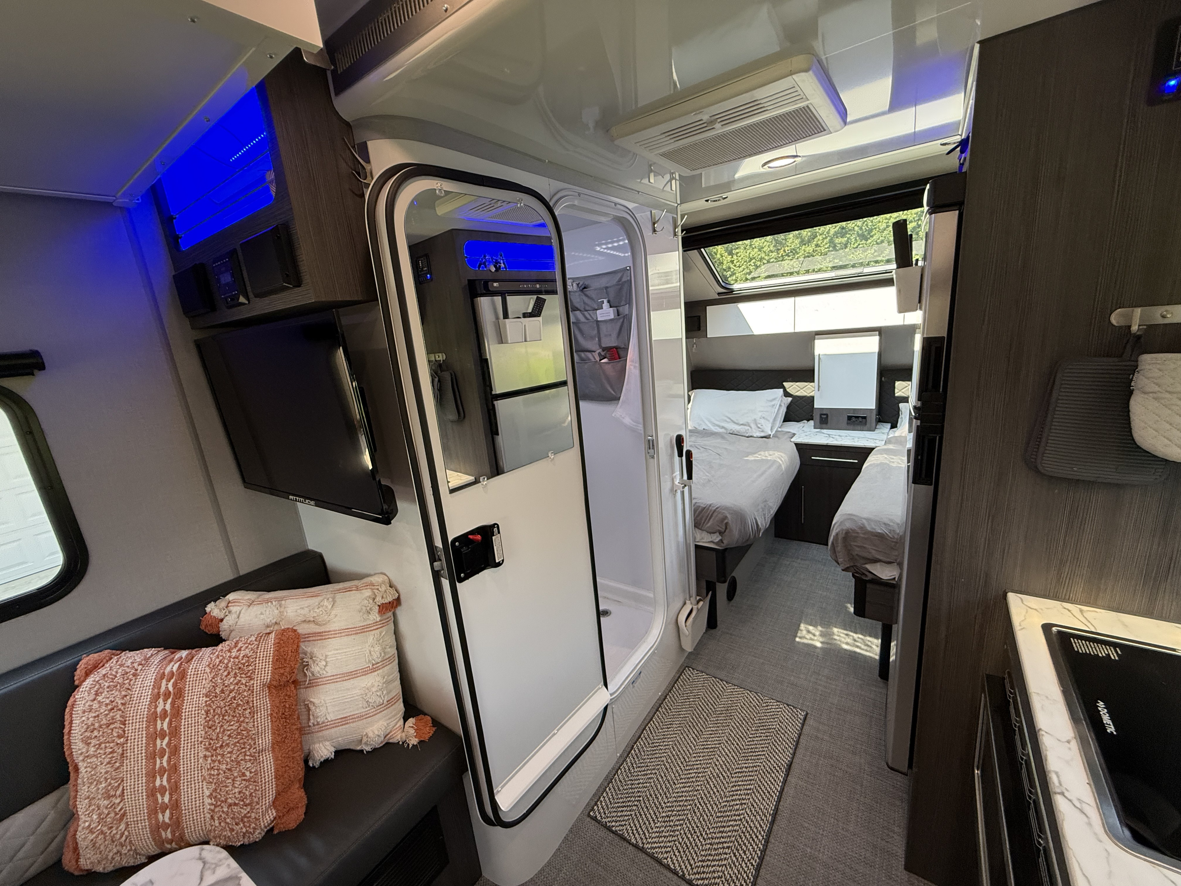 Experience this rv rental's sleek interior: twin beds, kitchen, cozy lounge, and blue accent lighting.. InTech RV O-V-R 2023