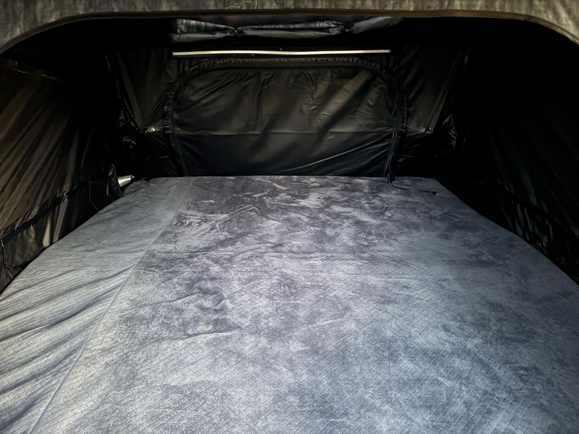 Cozy RV rental interior: comfortable sleeping area with quilted mattress for your next adventure.. Jeep Gladiator 2023