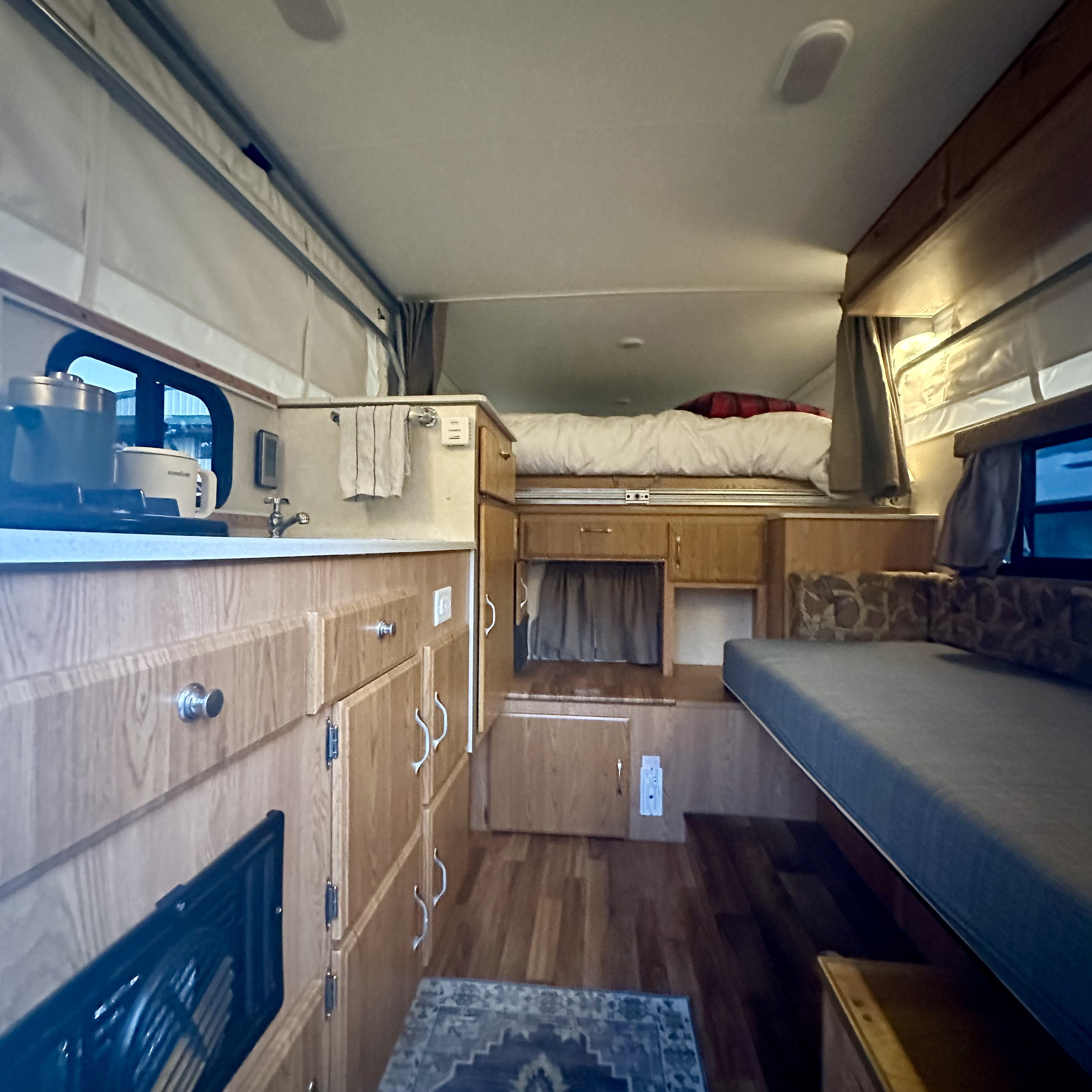 RV rental interior: A compact, functional living space with a kitchen, coffee maker, cozy bed, and dinette.. Dodge RAM 2500 2005