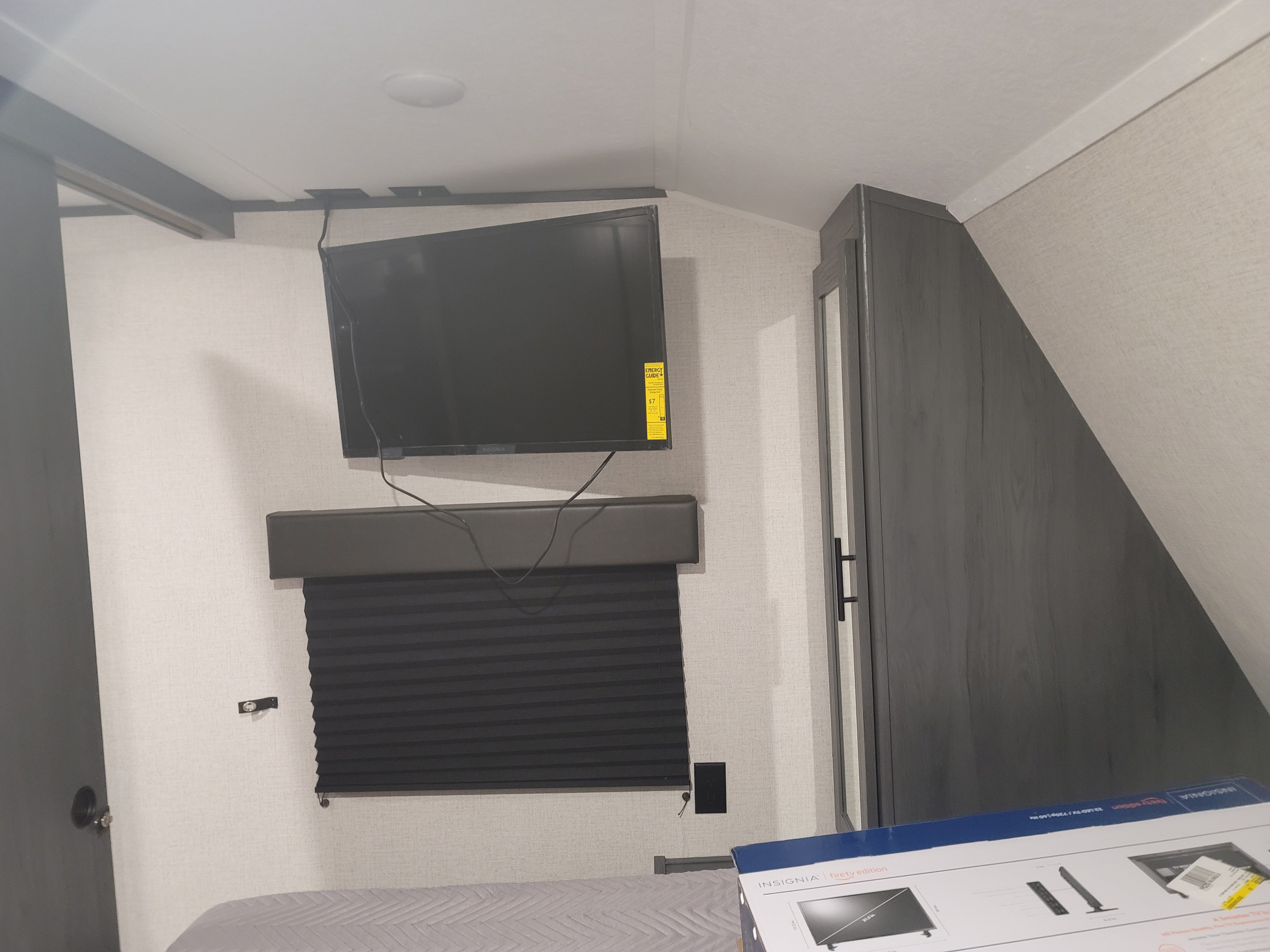 Cozy RV rental bedroom features a wall-mounted TV, privacy blinds, and storage cabinet.. Colorado 26bhc 2021