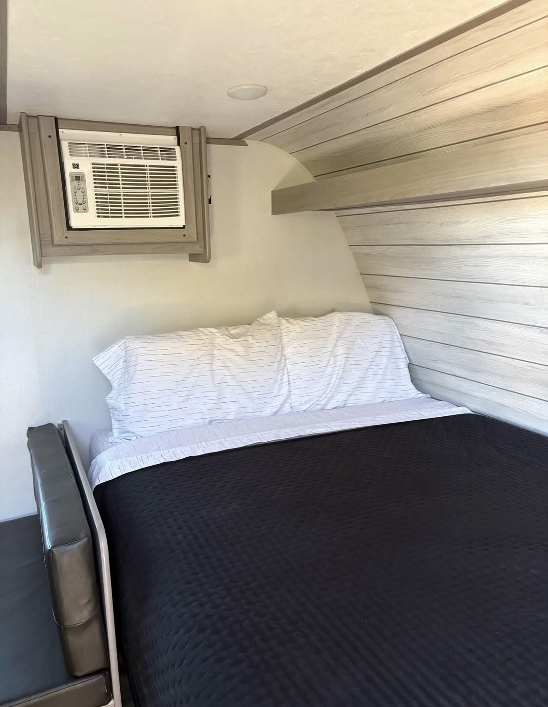 Inside this RV rental: a comfy bed, wall-mounted AC, and bench seating offer a compact, functional sleeping space.. Dutchmen Other 2024